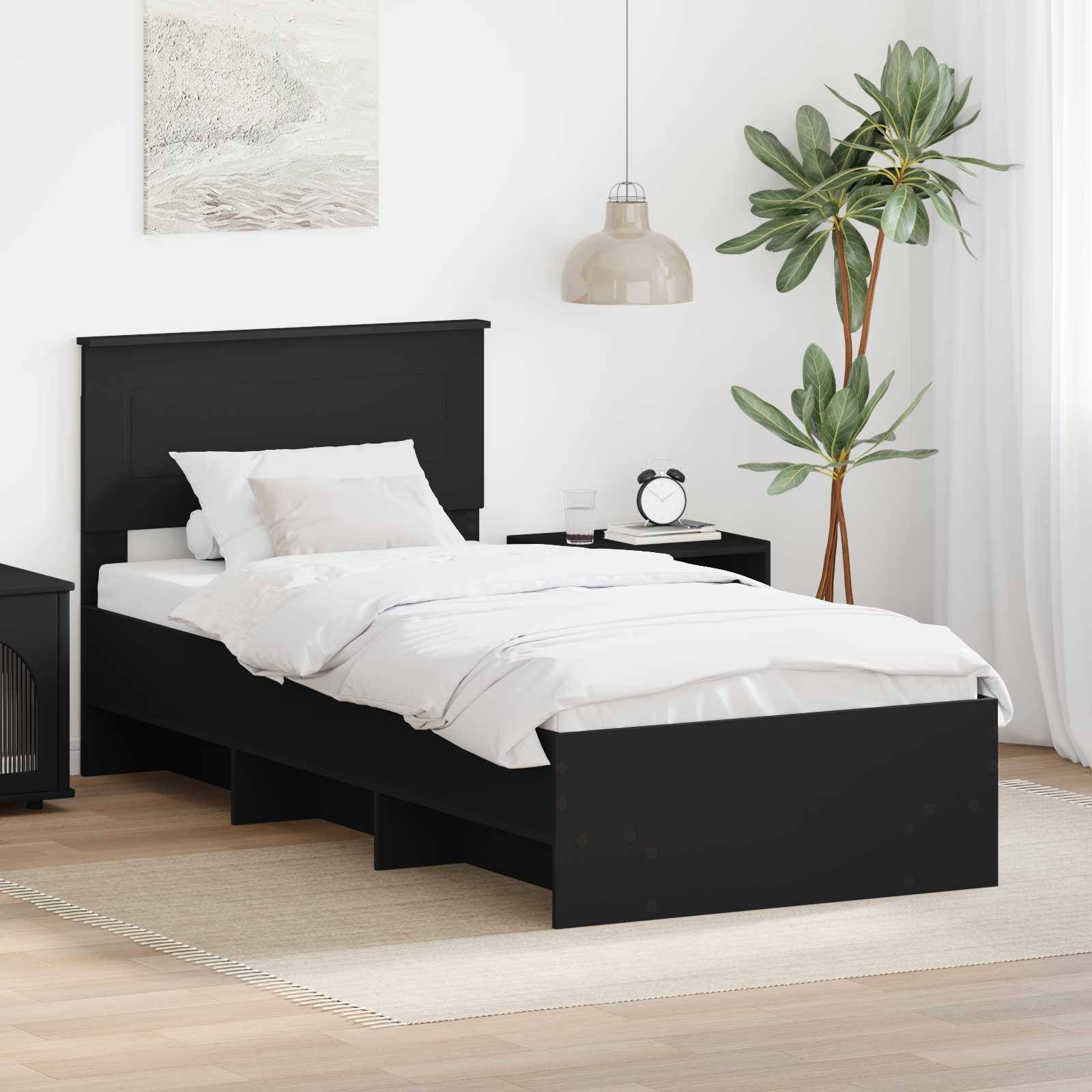 Ein minimalistisches Schlafzimmer mit einem schwarzen Bett, weißer Bettwäsche, einem Nachttisch mit Dekoration, einer hohen Pflanze und einer hängenden Lampe, die einen modernen Look kreiert.
