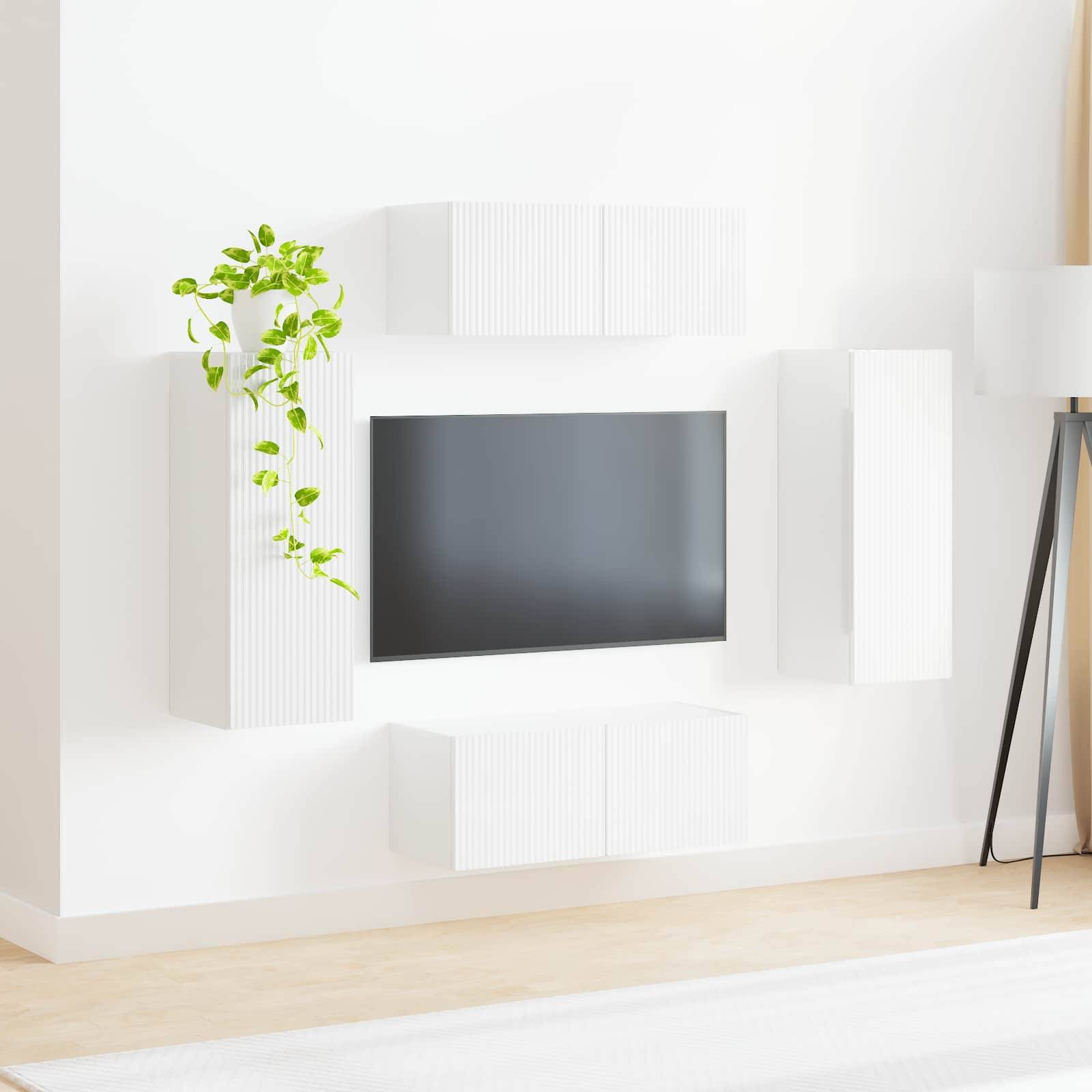 Ein modernes Wohnzimmer zeigt einen schlanken schwarzen Fernseher an einer weißen Wand, umgeben von weißen Schränken und einer Topfpflanze zur Dekoration.