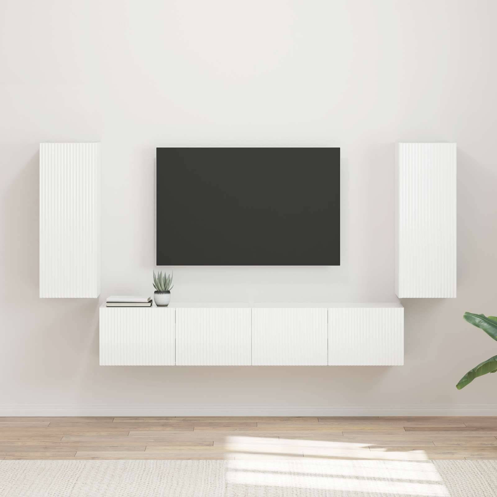 Moderner Wohnraum mit einer wandmontiertem Flachbild-Fernseher, umgeben von weißen Schränken und einer kleinen Pflanze auf einem Holzboden.