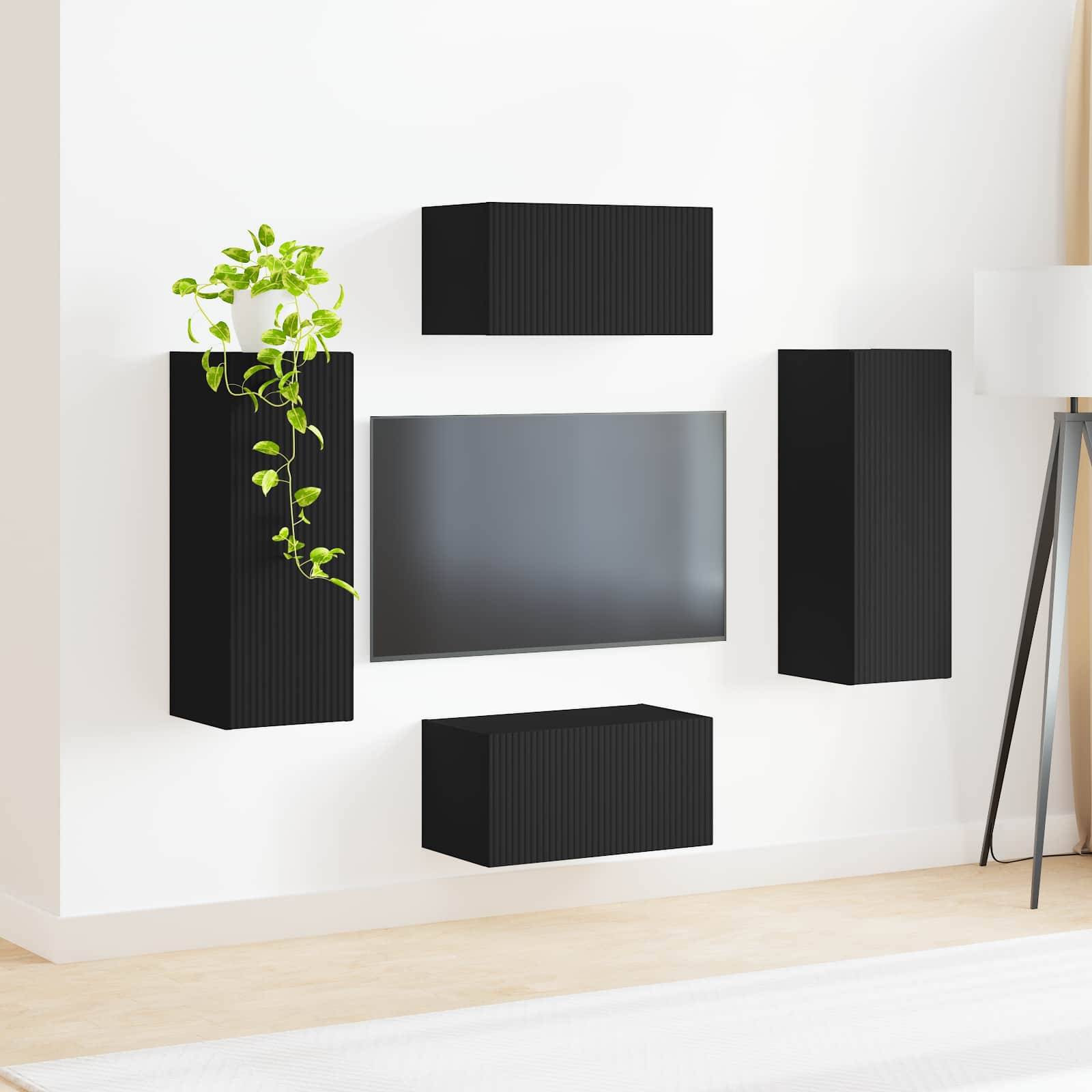 Ein moderner Wohnraum mit schwarzen wandmontieren minimalistischen Regalen, einem Breitbild-Fernseher und einer Topfpflanze auf einem hellen Holzboden.
