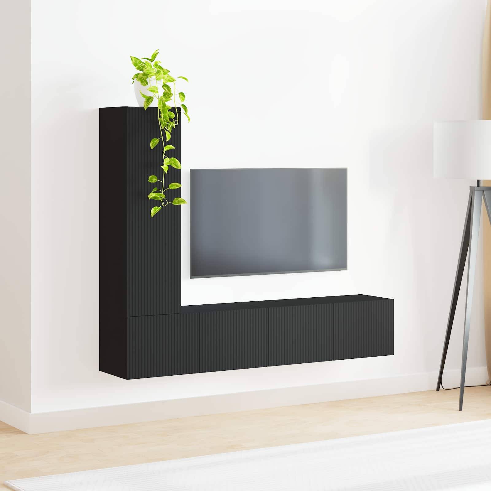 Ein moderner Wohnbereich zeigt einen montierten Flachbild-Fernseher, einen schwarzen Schrank mit einer grünen Pflanze darauf und eine elegante Stehlampe in der Nähe.
