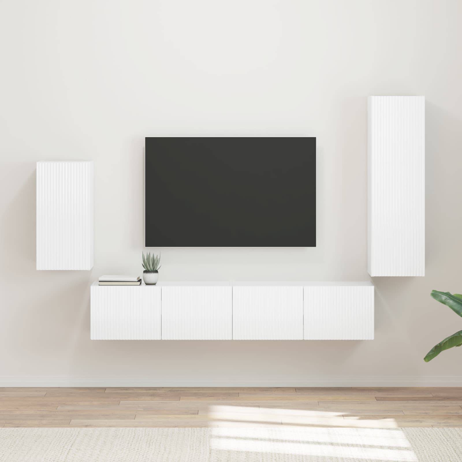 Ein minimalistisches Wohnzimmer zeigt einen an der Wand montierten Fernseher, weiße Schränke und eine kleine Pflanze, mit Holzboden und einem Teppich.
