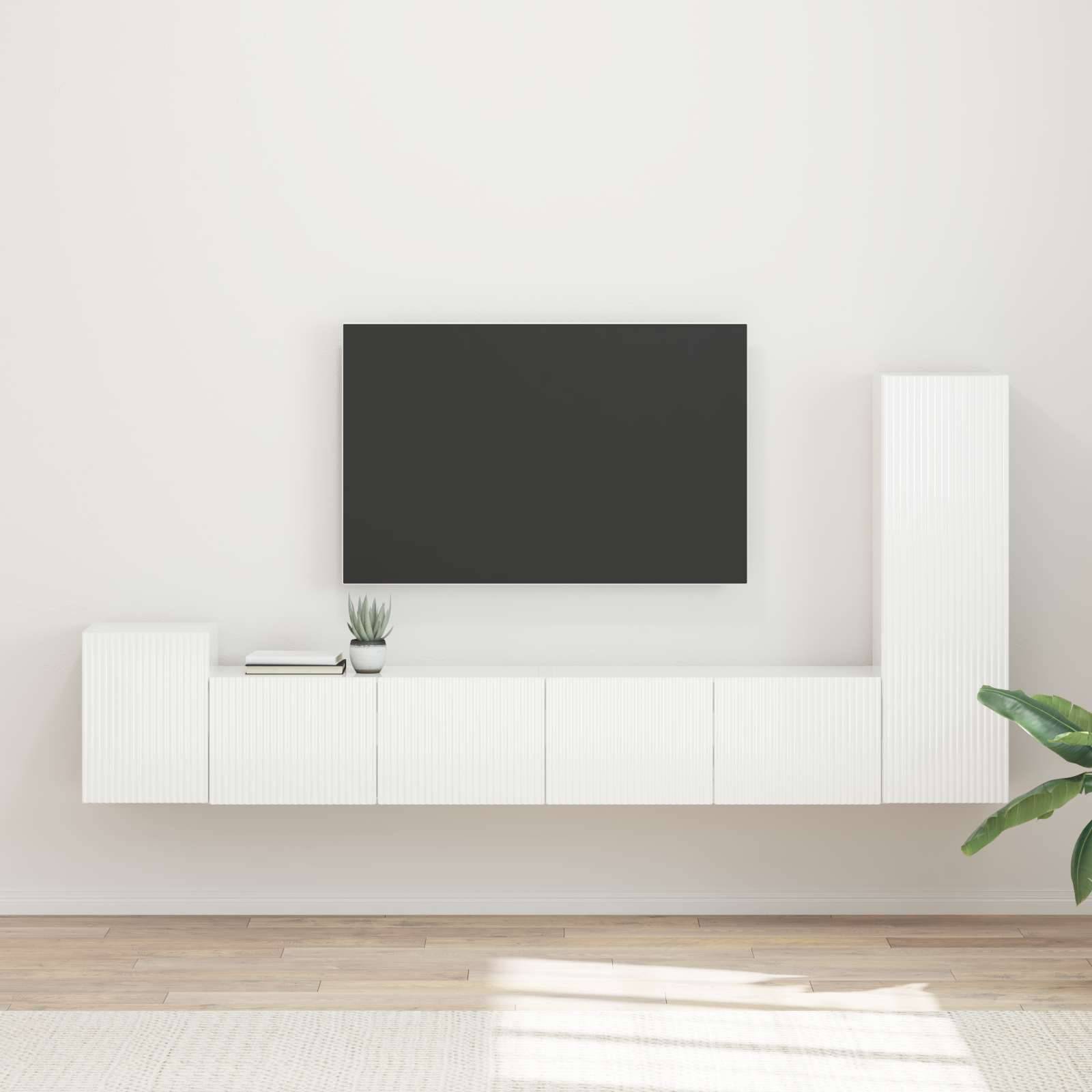 Ein minimalistisches Wohnzimmer-Setup mit einer an der Wand montierten TV-Konsole und einem weißen schwebenden Unterschrank, geschmückt mit einer kleinen Topfpflanze.