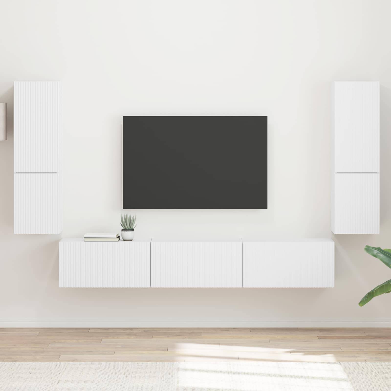 Modernes Wohnzimmer mit einem an der Wand montierten Fernseher, der mittig über eleganten weißen Schränken platziert ist; minimalistisches Design mit hellem Holzboden.