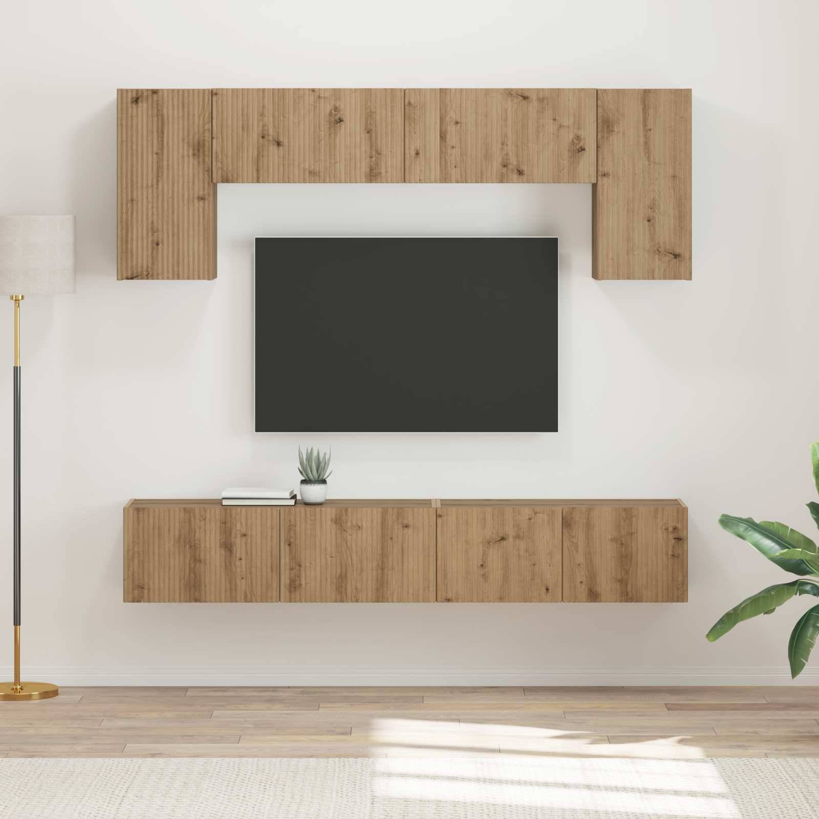 Moderner Wohnraum mit an der Wand befestigten Holzregalen, die einen Flachbildschirm-Fernseher umrahmen. Eine Stehlampe und eine Pflanze ergänzen die dekorativen Elemente.