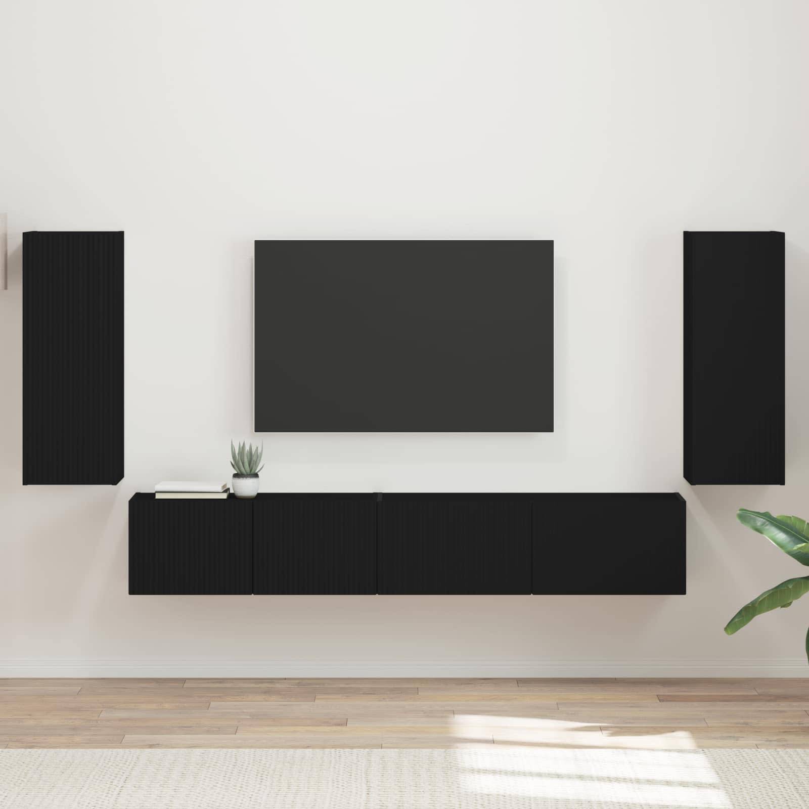 Ein minimalistisches Wohnzimmer-Setup zeigt einen an der Wand montierten schwarzen Fernseher, flankiert von vertikalen schwarzen Lautsprechern. Eine schwarze Konsole mit einer kleinen Pflanze darunter komplettiert die Dekoration.