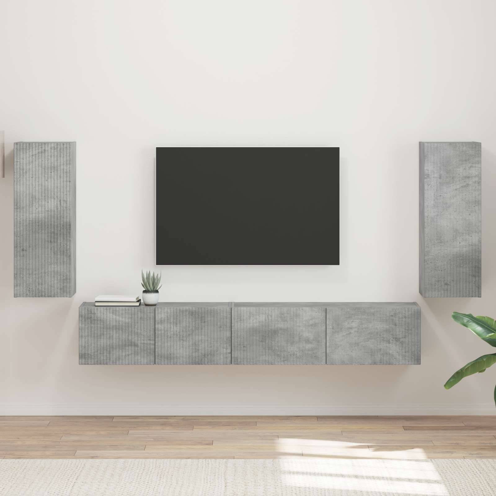 Eine moderne Wohnzimmerwand mit einem Flachbildfernseher in der Mitte, umgeben von minimalistischen, grauen Aufbewahrungsschränken; eine Pflanze steht auf dem Schrank.