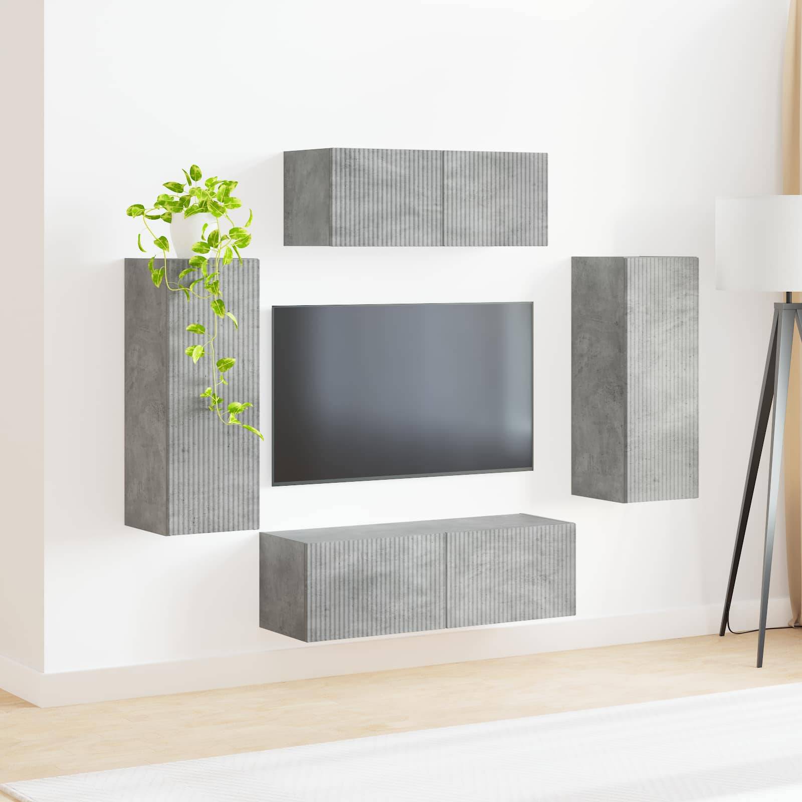Ein minimalistisches Wohnzimmer-Setup mit einem an der Wand montierten grauen Fernseher, umgeben von schwebenden Schränken und einer kleinen grünen Pflanze auf einem der Schränke.