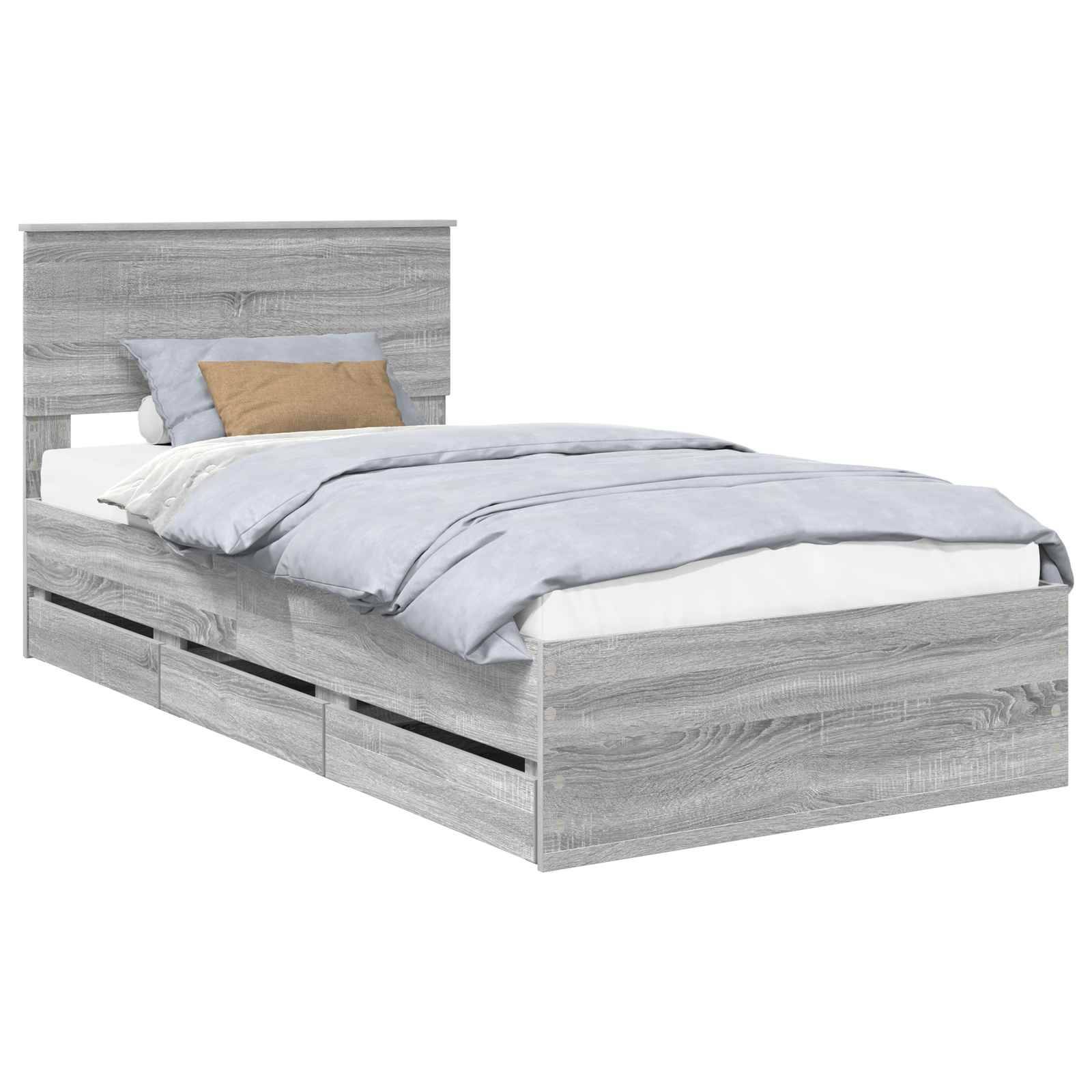Ein grauer Holzbettrahmen mit einem Kopfteil, Kissen, beige und grauen Bettwäschestücken und vier Staurageschubladen darunter.