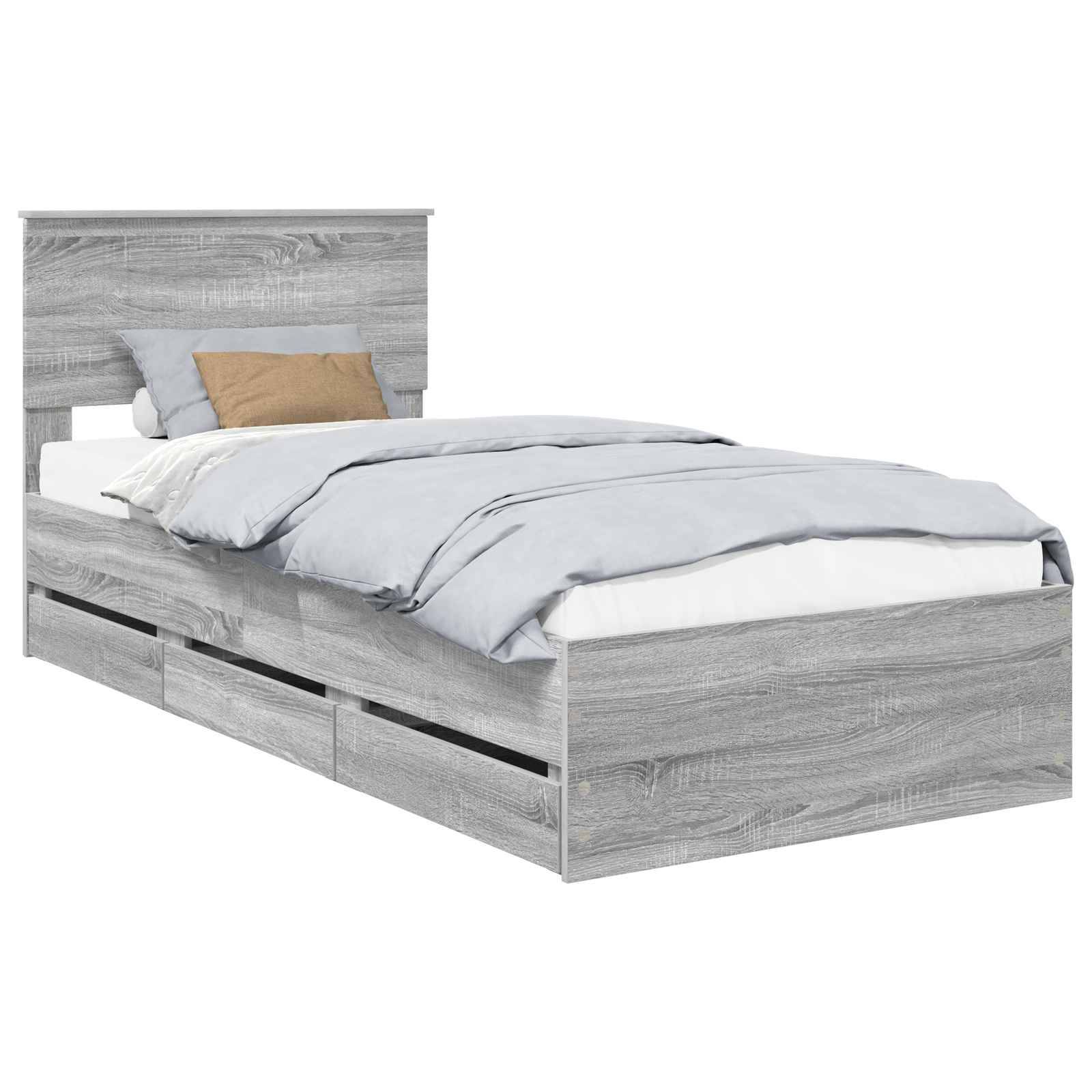 Ein Holzbett in Einzelgröße mit grauer Lackierung, grauer Bettwäsche und einem braunen Kissen. Das Bett verfügt über integrierte Aufbewahrungsschubladen darunter.