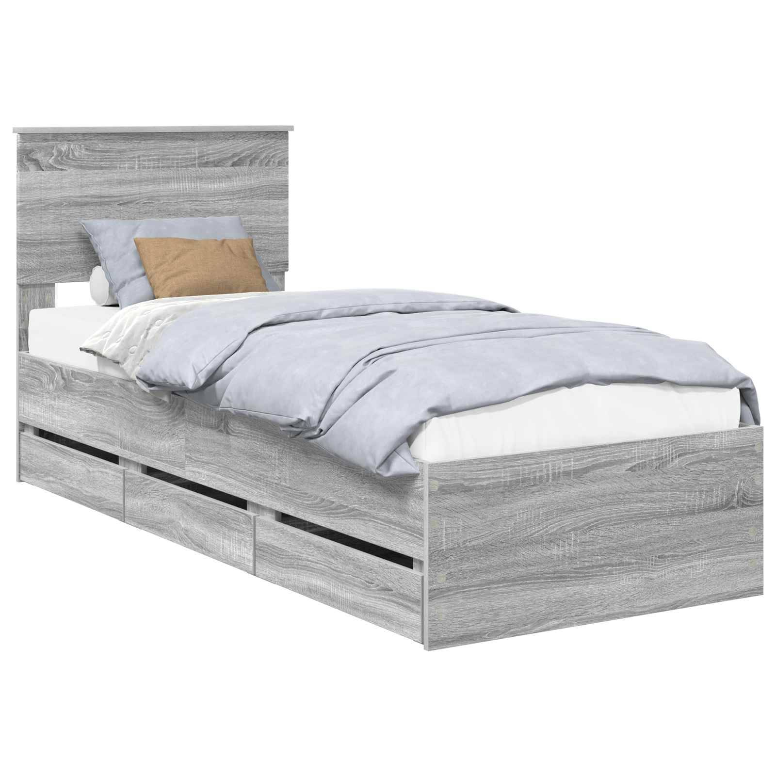 Ein Einzelbett mit einem grauen Holzrahmen, Kopfteil und drei Aufbewahrungsschubladen darunter. Es hat hellgraue Bettwäsche mit zwei Kissen.
