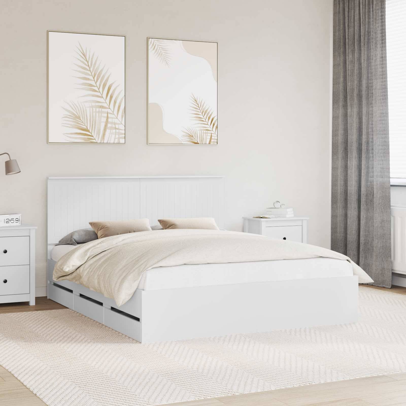 Ein modernes Schlafzimmer mit einem weißen Bett mit neutraler Bettwäsche, zwei abstrakten Blattdrucken an der Wand und einem Fenster mit grauen Vorhängen.