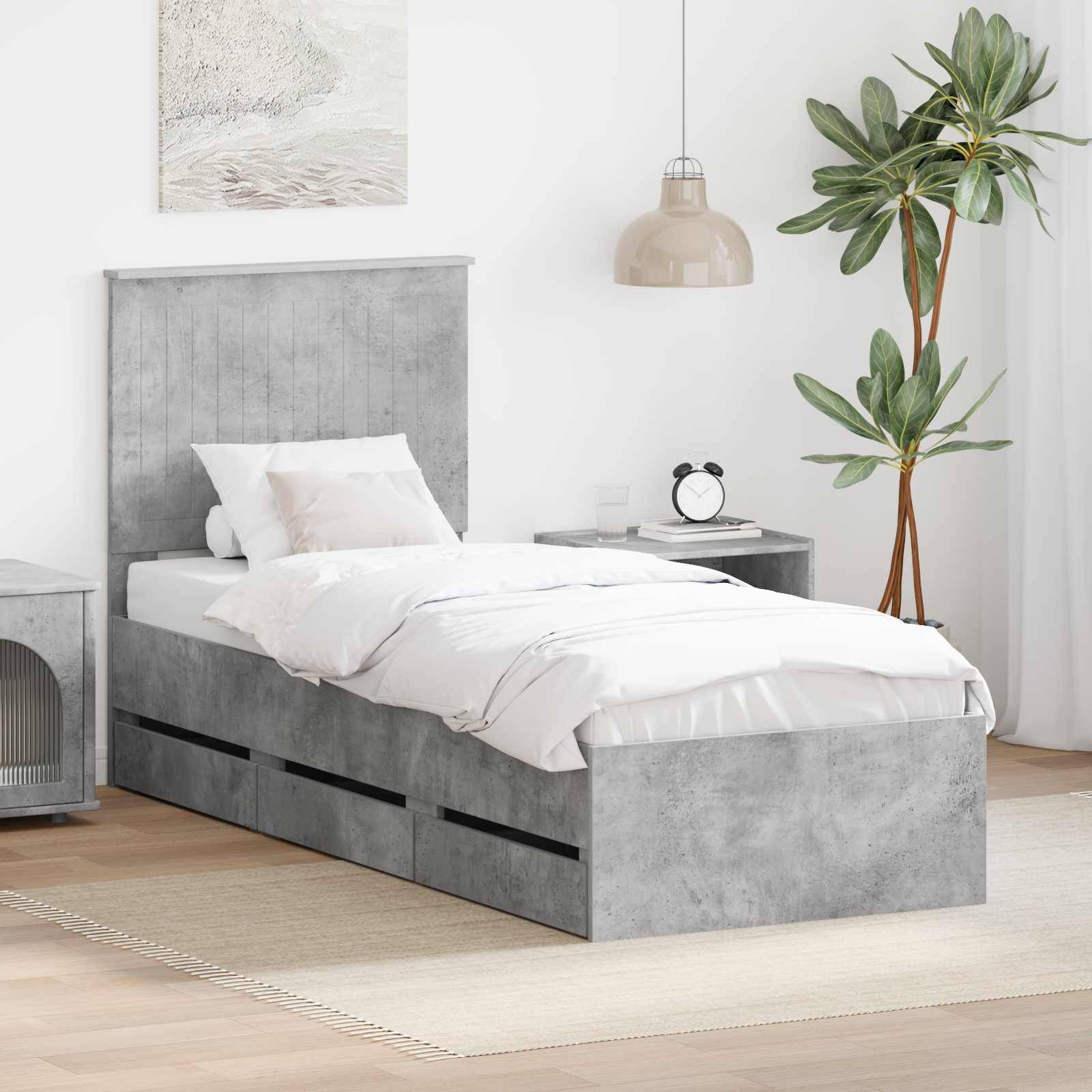 Ein minimalistisches Schlafzimmer mit einem Bett mit grauem Kopfteil, weißer Bettwäsche und integrierten Lagerschubladen. Ein kleiner Nachttisch und eine Topfpflanze befinden sich in der Nähe.