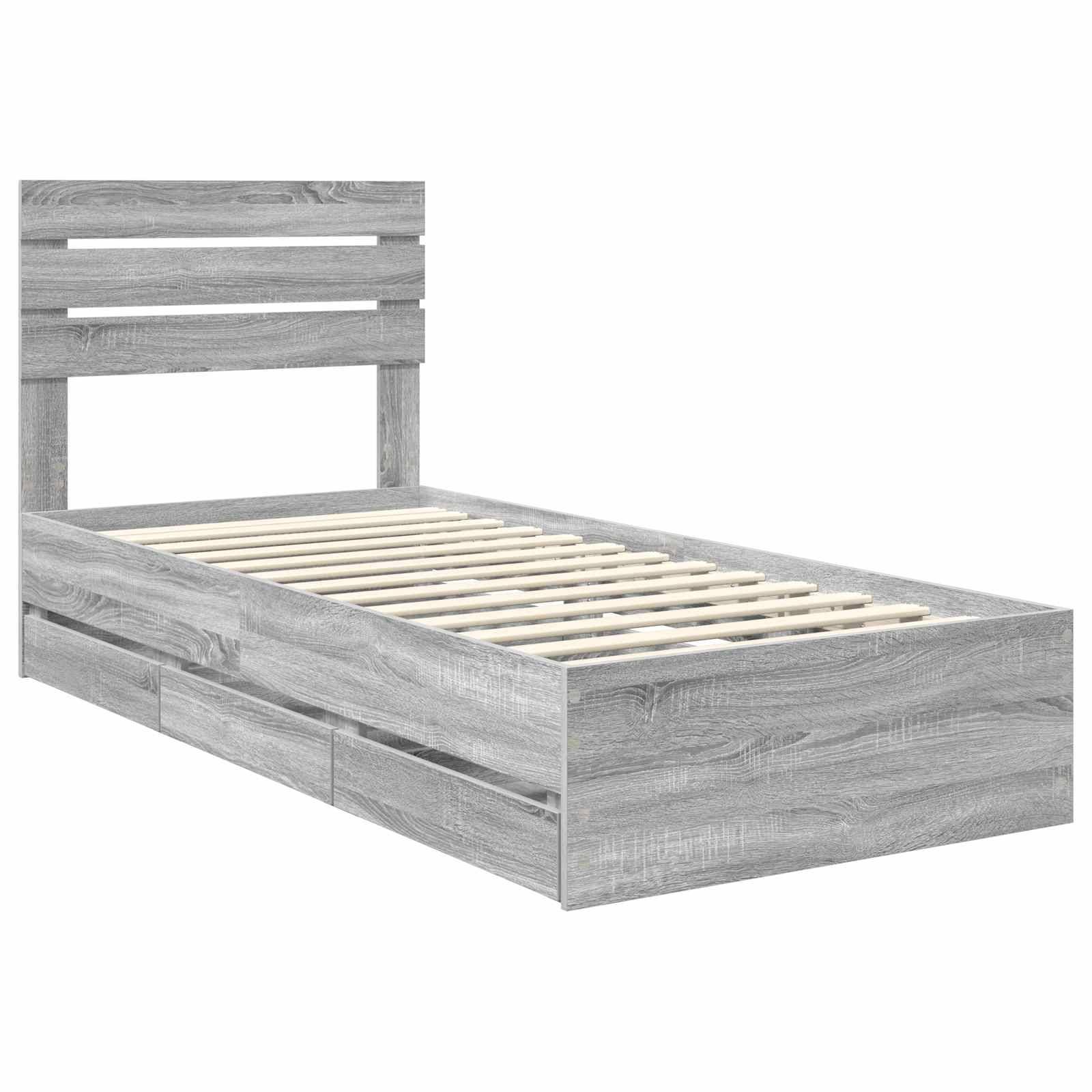 Ein grauer Holz-Einzelbettrahmen mit einem geschlitzten Kopfteil und Unterbett-Schubladen, vor einem schlichten weißen Hintergrund.