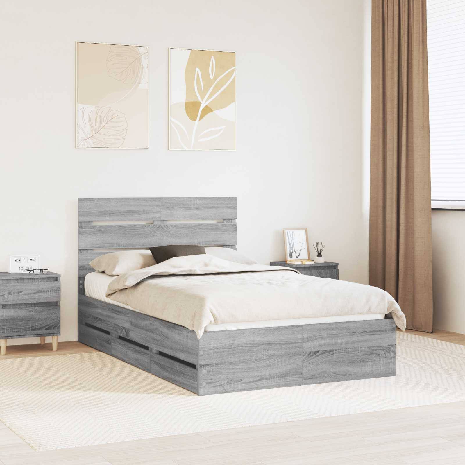 Ein modernes Schlafzimmer mit einem grauen Holzbett, das Aufbewahrungsschubladen besitzt, beigefarbener Bettwäsche, passend dazu ein Nachttisch und minimalistische Kunstwerke über dem Bett.