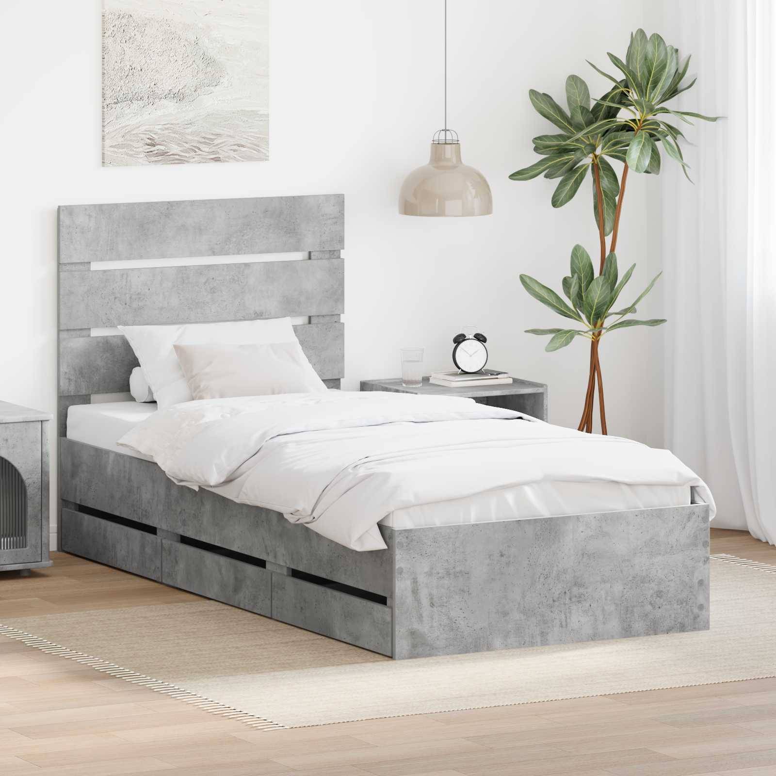 Modernes Schlafzimmer mit einem grauen Betonbett, weißer Bettwäsche, einem Nachttisch, einer Topfpflanze und einer kleinen Pendelleuchte.