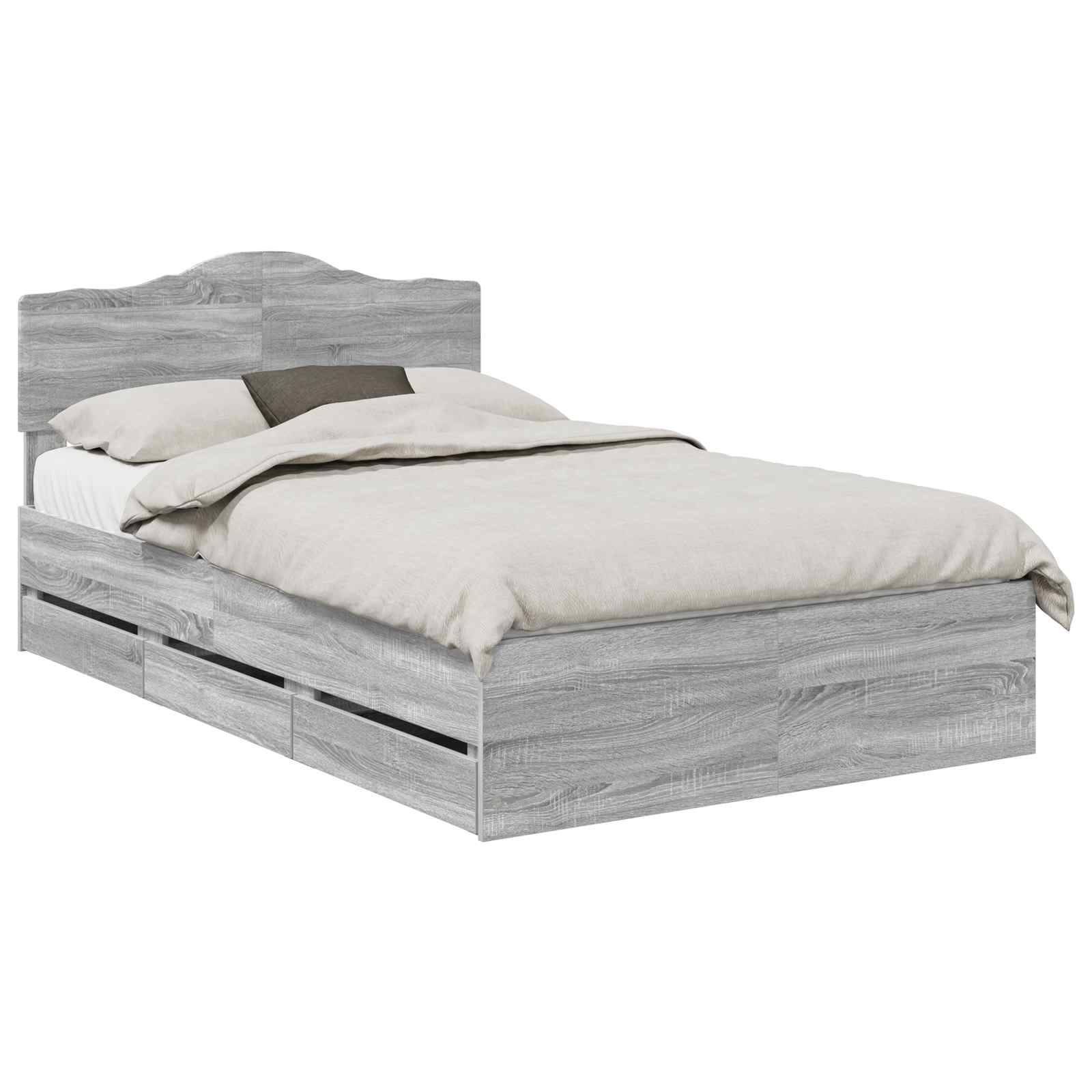 Ein Holzbettgestell mit grauer Beschichtung verfügt über einen Kopfteil und mehrere Staurageschubladen darunter. Das Bett ist ordentlich gemacht, mit beigefarbener Bettwäsche.