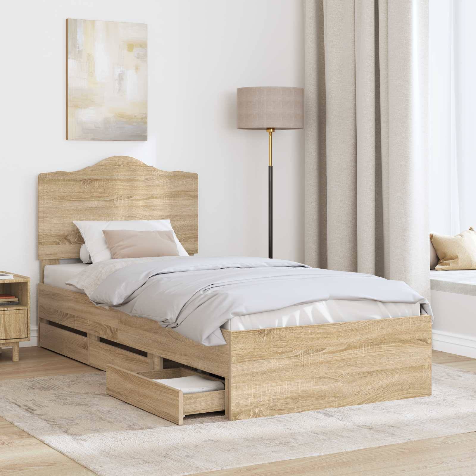 Ein Schlafzimmer mit einem Holzbett, das eine Schublade darunter hat, zwei weißen Kissen, einer beigefarbenen Decke, einem Nachttisch, einer Lampe und einer Fensterbank mit Sitzplatz.