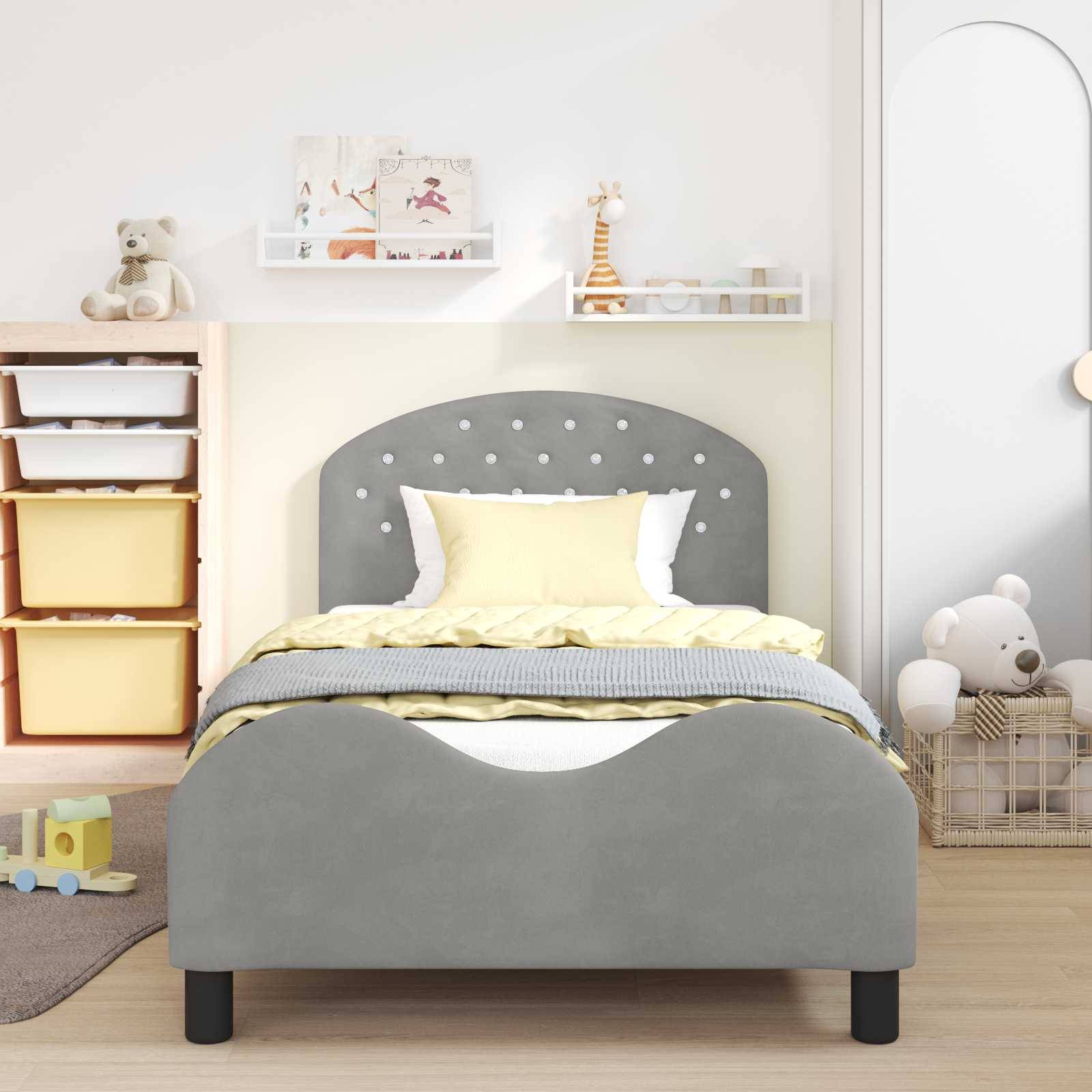 Ein Kinderzimmer mit einem grauen Bett, gelb-weißer Bettwäsche, Spielzeugkisten links und Plüschtieren. Die Wände sind hell und mit dekorativen Regalen versehen.