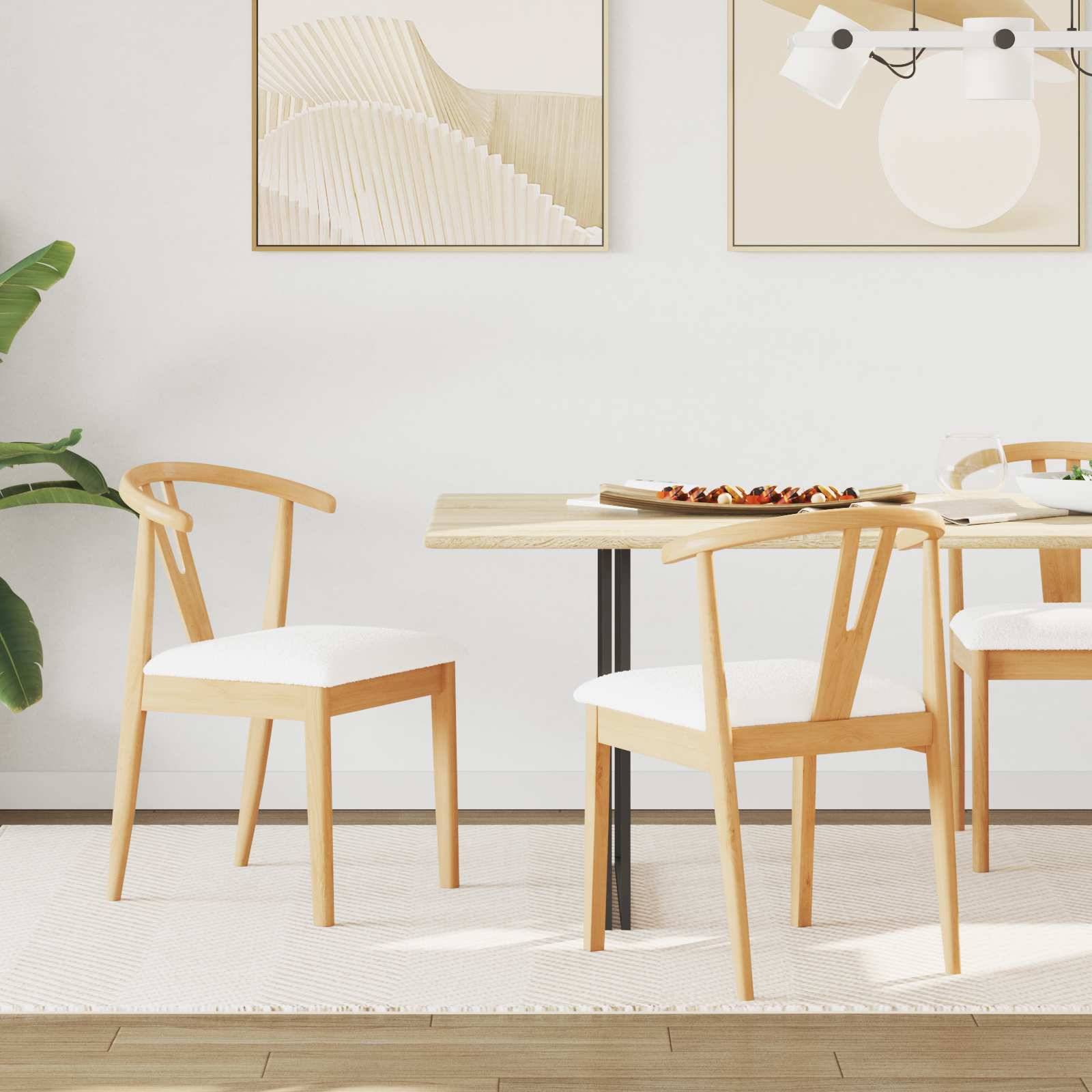 Moderner Essbereich mit einem Tisch aus hellem Holz, vier Stühlen mit weißen Kissen, abstrakter Wandkunst und einer Zimmerpflanze. Helle, minimalistische Einrichtung.