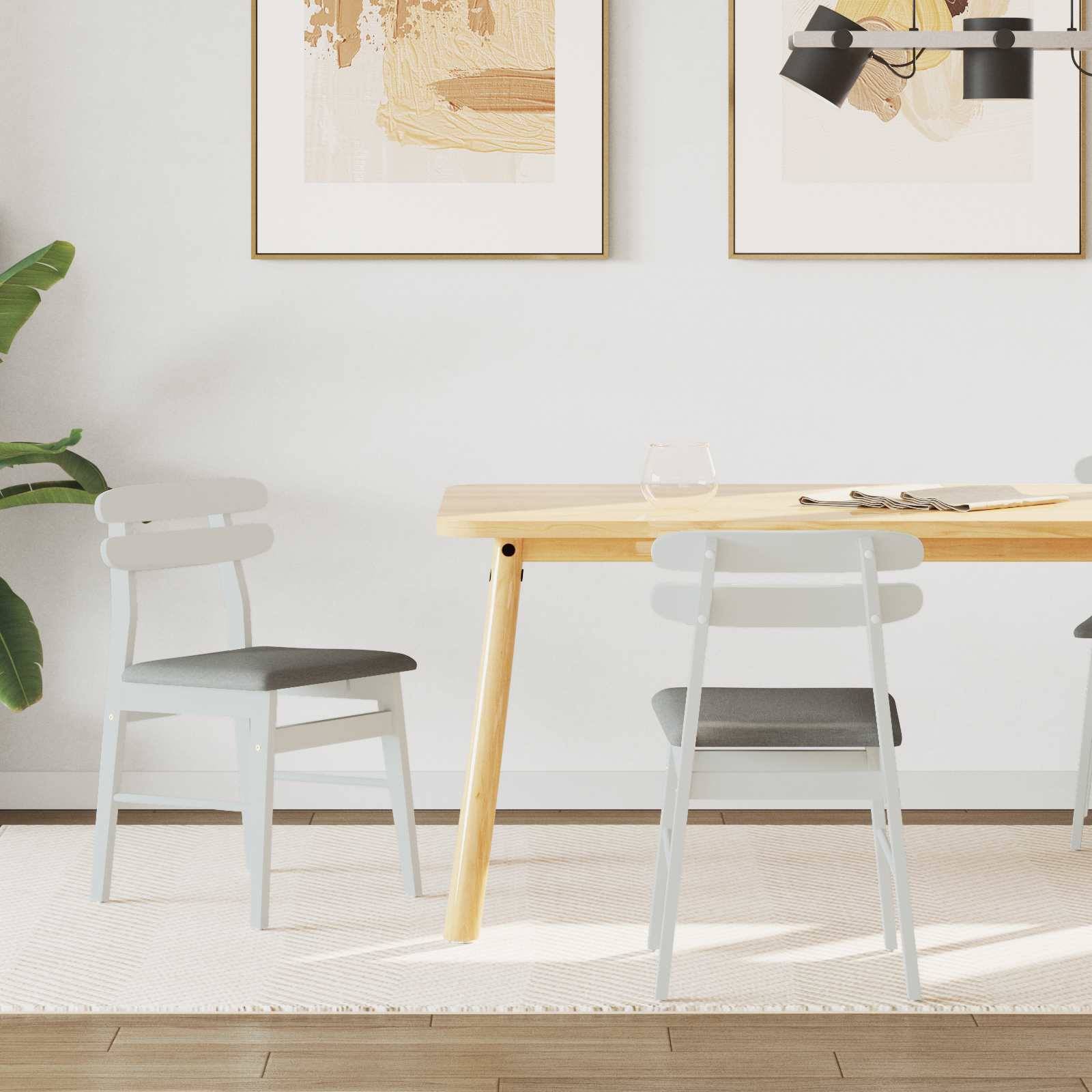 Minimalistisches Esszimmer mit einem Tisch aus hellem Holz, zwei grauen Stühlen, abstraktem Kunstwerk an der Wand und einer Topfpflanze in der Ecke.