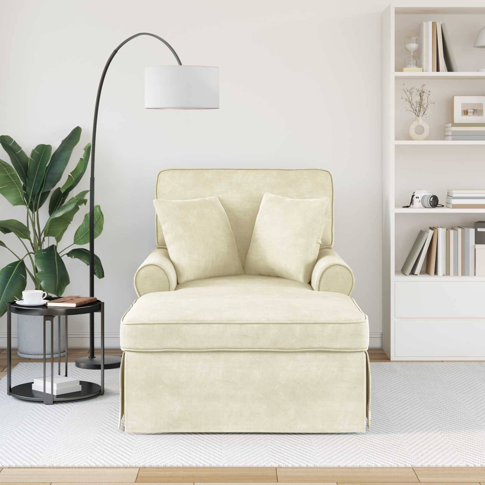 Ein gemütlicher cremefarbener Sessel mit zwei Kissen, der neben einer hohen Stehlampe platziert ist. Rechts davon befindet sich ein weißes Bücherregal, gefüllt mit Dekorationen und Büchern.