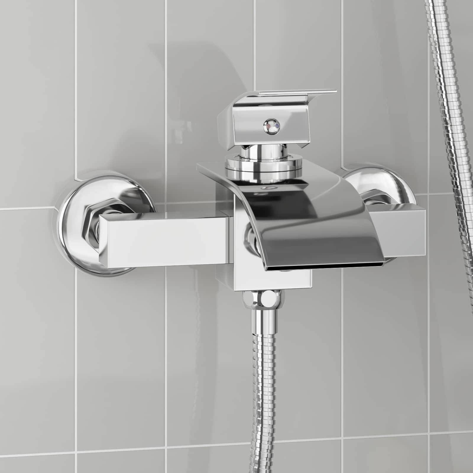 Eine schlanke, moderne Chrom-Wandarmatur für die Badewanne mit Hebelgriff und breitem Auslauf, vor einer grauen gefliesten Wand.