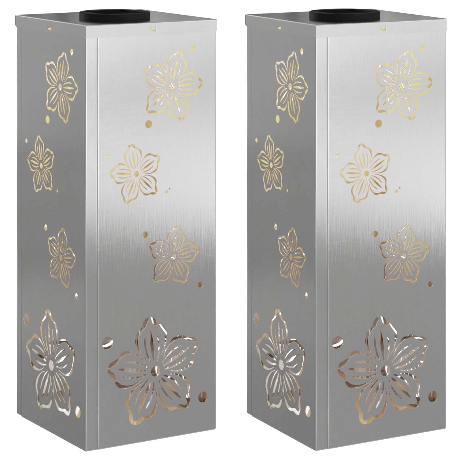 Zwei vertikale Metallzylinder mit floralem Ausschnittdesign, jeder mit einer oberen Öffnung, wahrscheinlich für dekorative oder funktionale Zwecke verwendet.