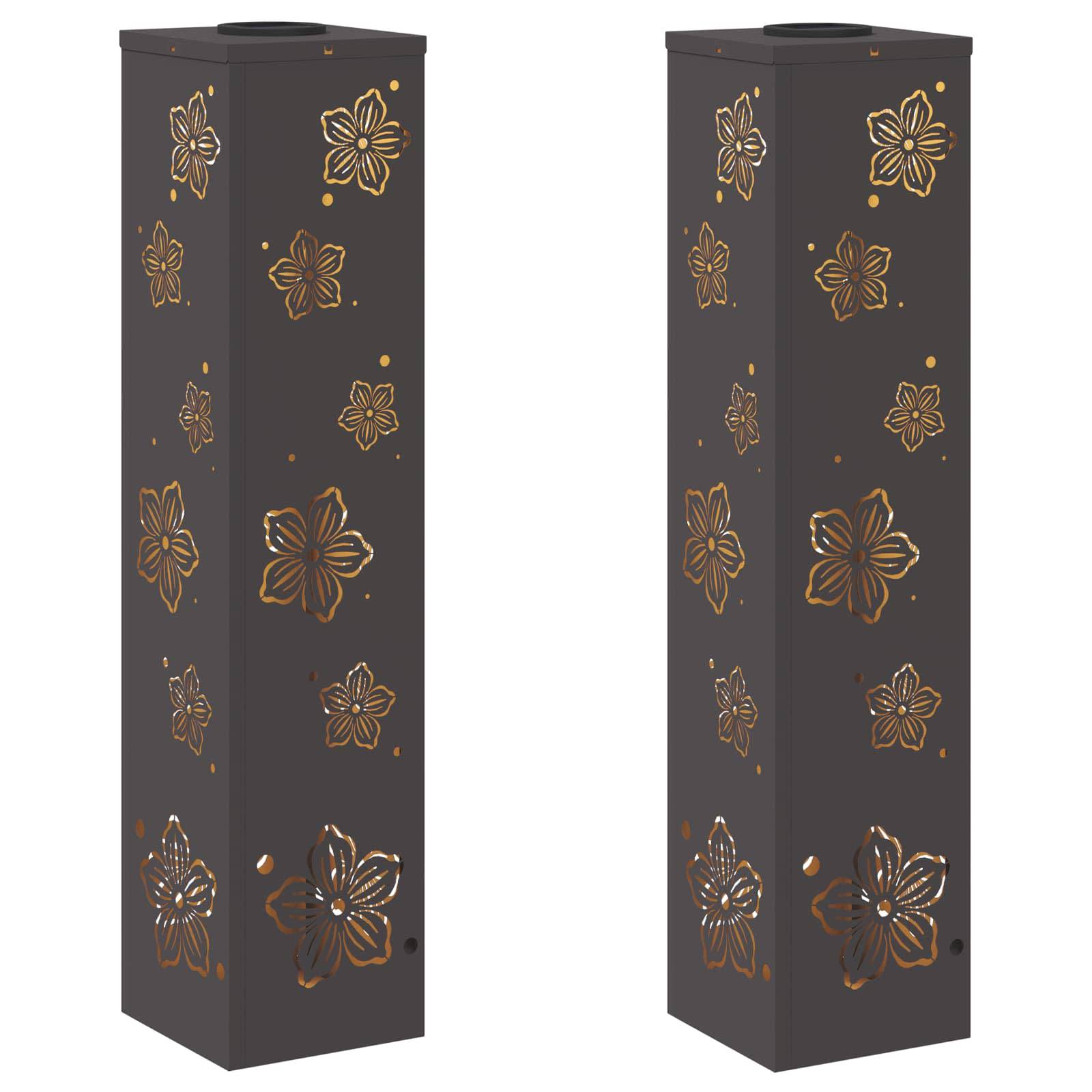 Zwei hohe, schwarze Ziersäulen mit floralen Ausschnittmustern, die es dem Licht ermöglichen, hindurchzuscheinen. Jede Säule weist identische Muster auf.