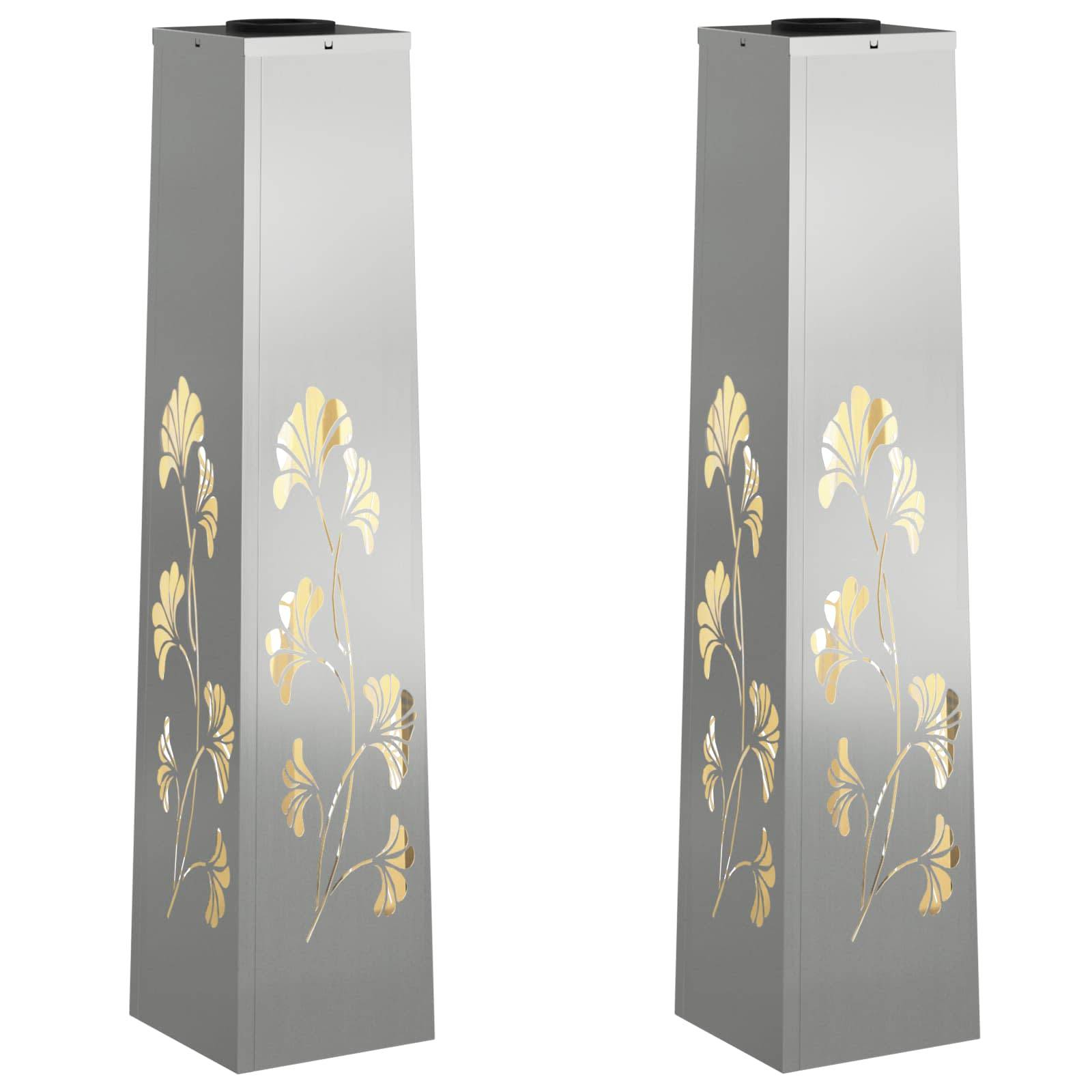 Zwei hohe, silberne Metalltürme mit gelben Blumenmustern an jeder Seite. Das Muster ist symmetrisch und auf beiden Türmen wiederholt.