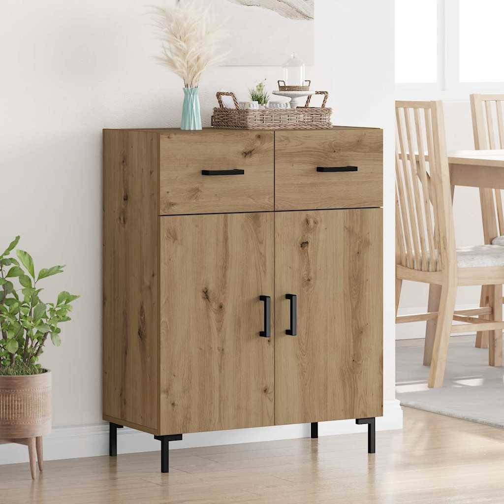 Ein heller Holzschrank mit zwei Schubladen und zwei Türen, versehen mit schwarzen Griffen, steht in einem Raum. Eine Vase mit Pampasgras und Dekorationen befindet sich auf der Oberfläche.