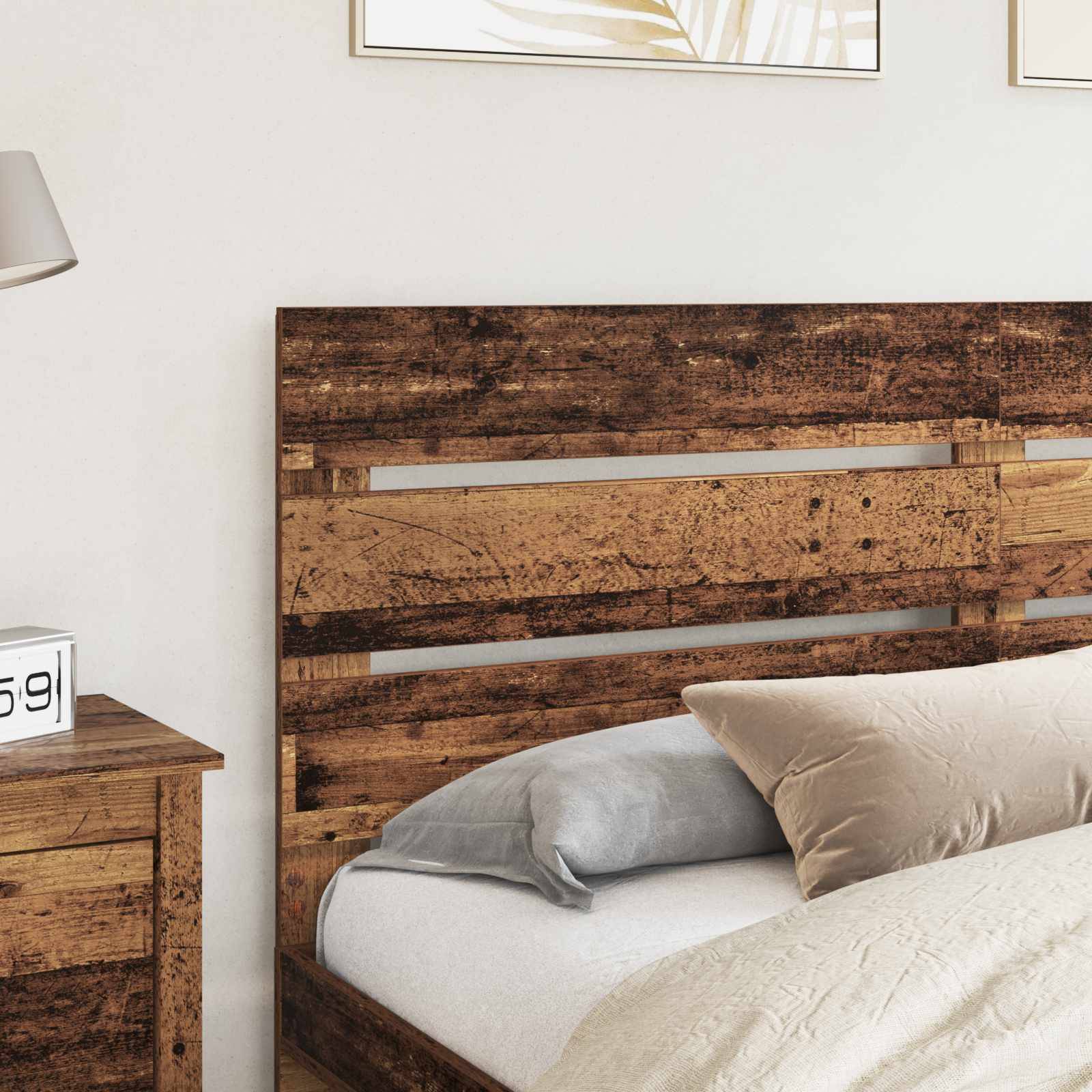 Ein Holzbett mit neutraler Bettwäsche und Kissen vor einem passenden Holzkopfteil. Ein Nachttisch ist teilweise sichtbar.