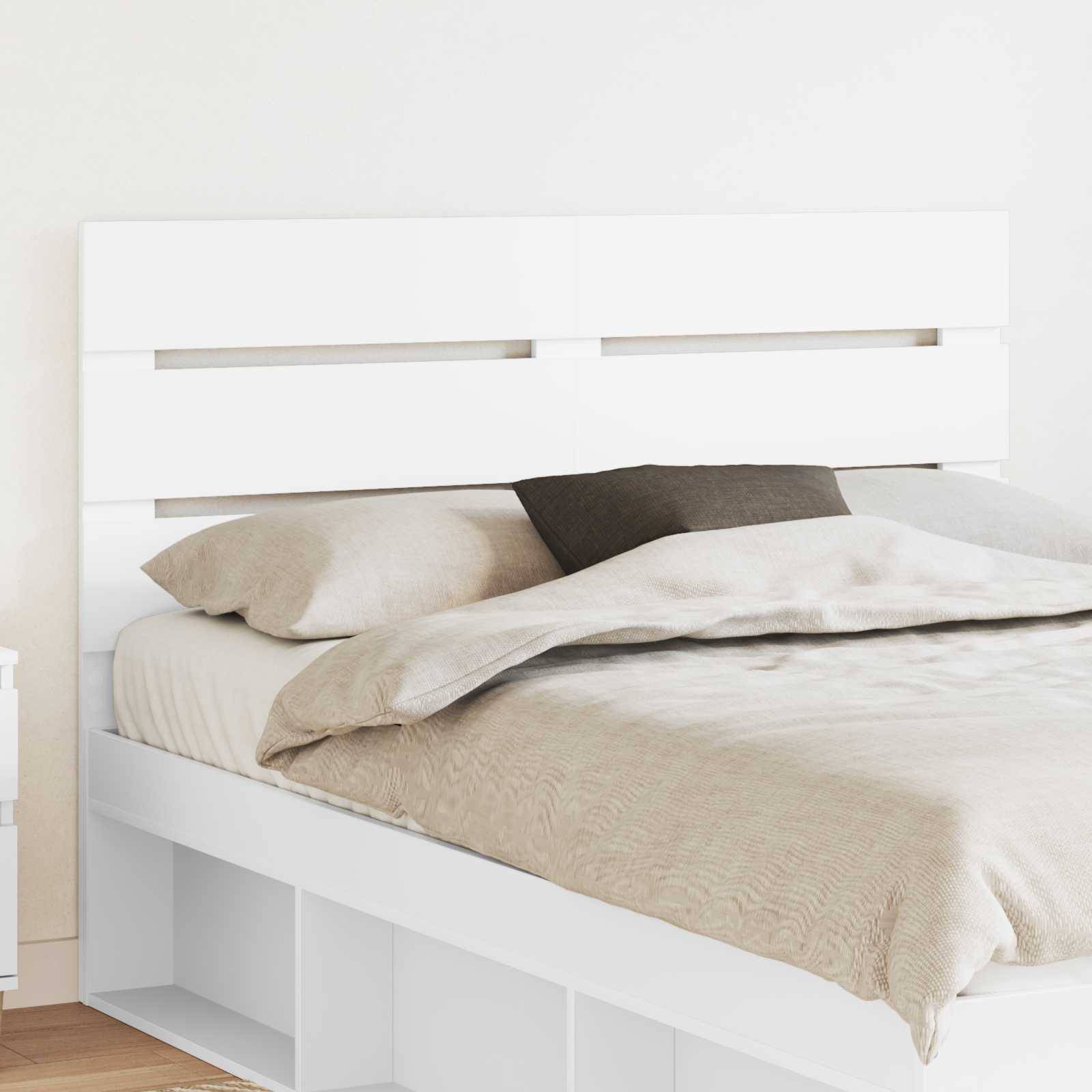 Ein ordentlich gemachtes Bett mit beigefarbener Bettwäsche und einem dunklen Akzentkissen, vor einem weißen Kopfteil mit horizontalen Lamellen.