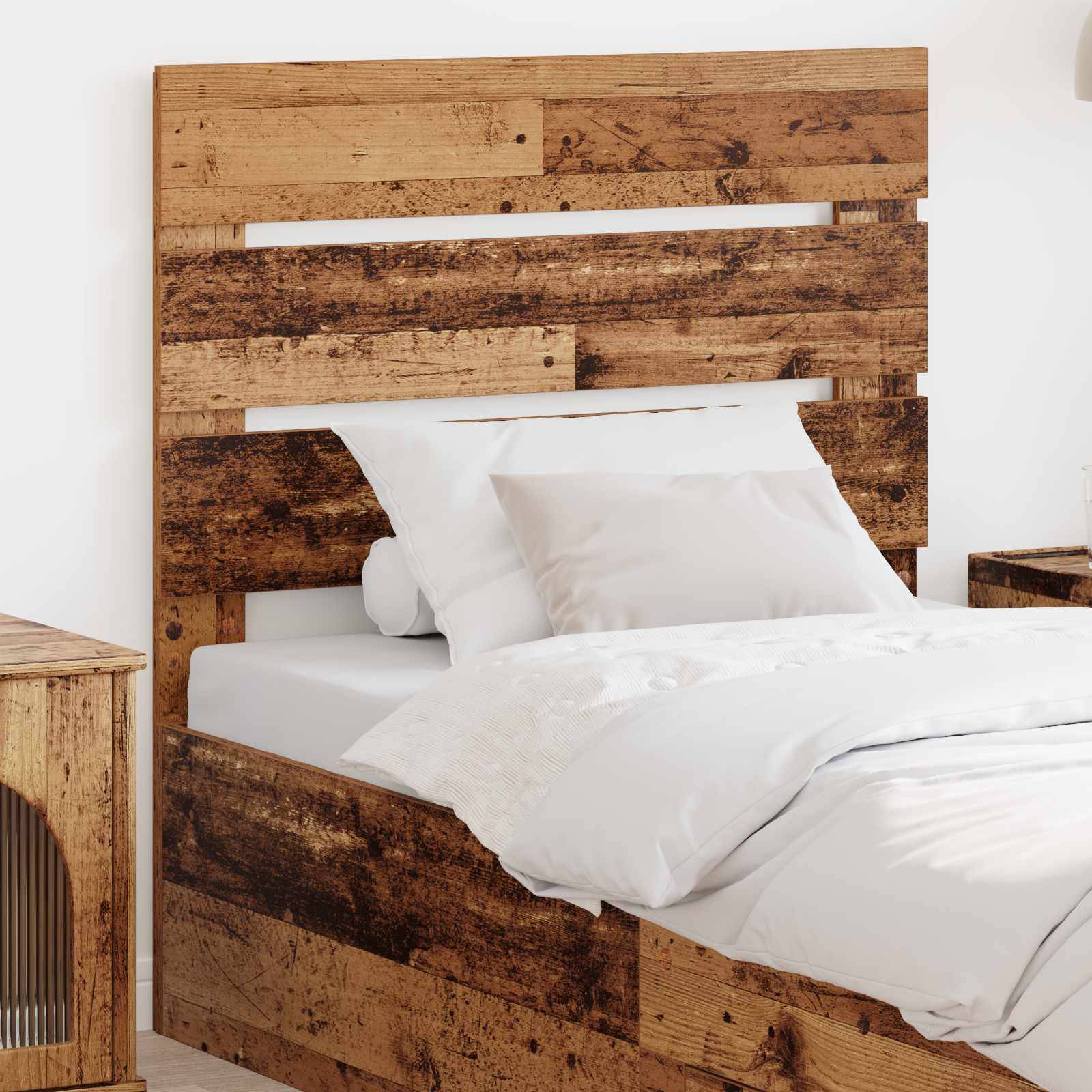 Ein rustikales Holzbett mit weißer Bettwäsche in einer minimalistischen Schlafzimmereinrichtung, mit einem passenden Holz-Nachttisch.
