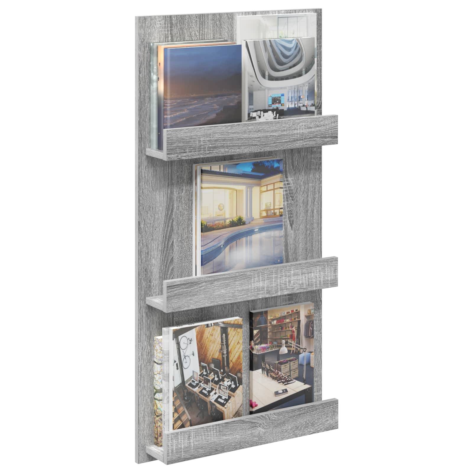 Ein grauer, an der Wand montierter Zeitschriftenhalter enthält drei Reihen von Zeitschriften mit verschiedenen Architektur- und Innenarchitekturbildern.
