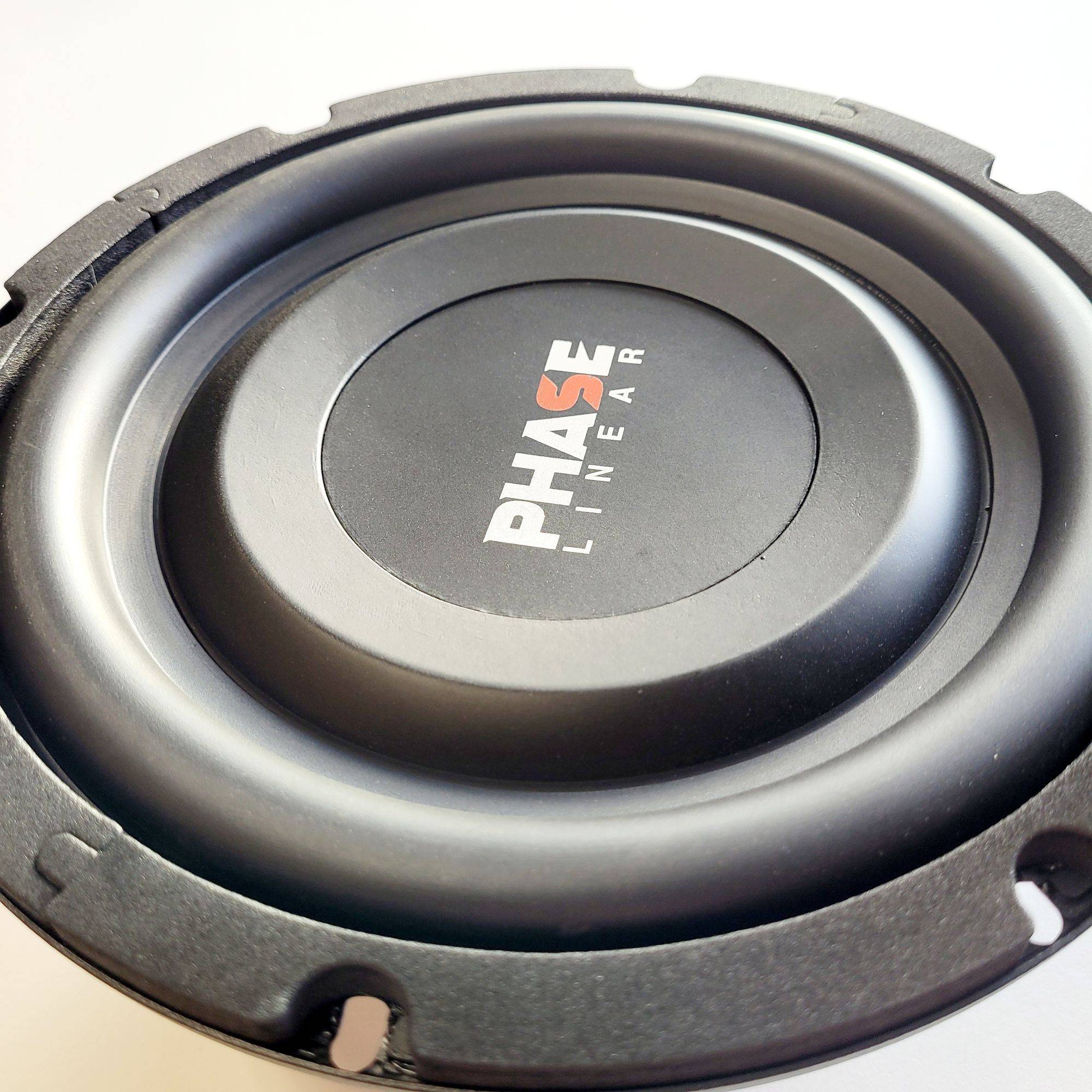 Ein schwarzer Lautsprecherkegel mit den Worten 'Phase Linear', in Weiß und Orange auf dem Staubschutz gedruckt, vor einem weißen Hintergrund.