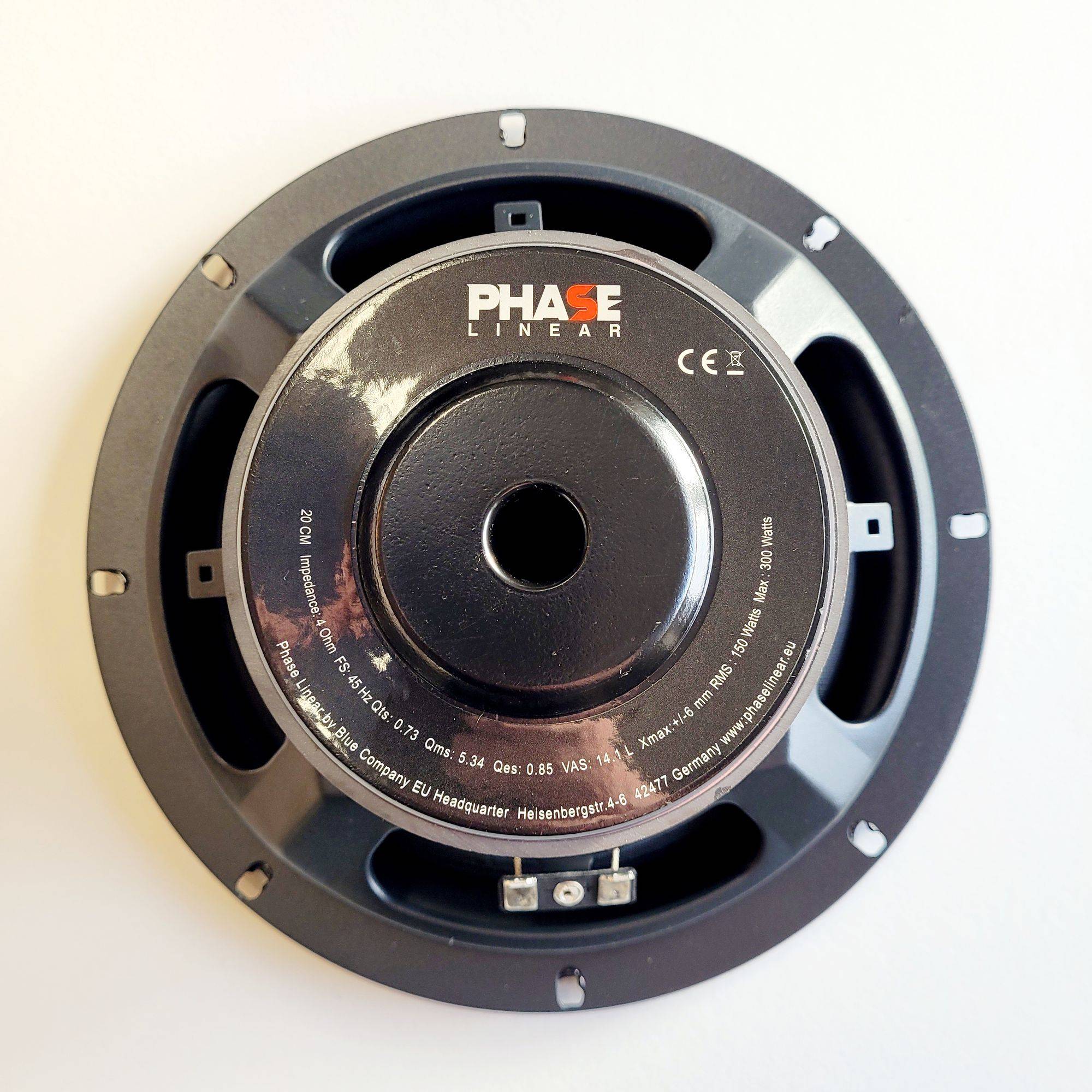 Ein 'Phase Linear' Lautsprecherkomponent mit sichtbaren technischen Details und Markenlogo. Kreisförmiges Design mit schwarzem Gehäuse auf einem neutralen Hintergrund.