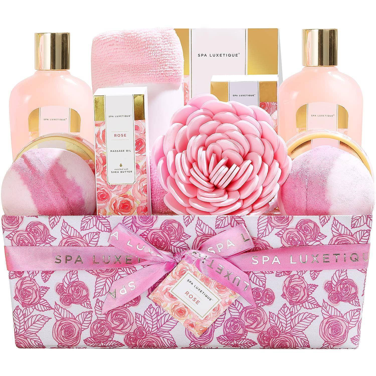 Ein rosa und goldener Spa-Geschenkkorb enthält Körperlotionen, Badebomben, ein rosa Handtuch und eine Dekorationsblume, die alle in einer Blumenbox angeordnet sind.