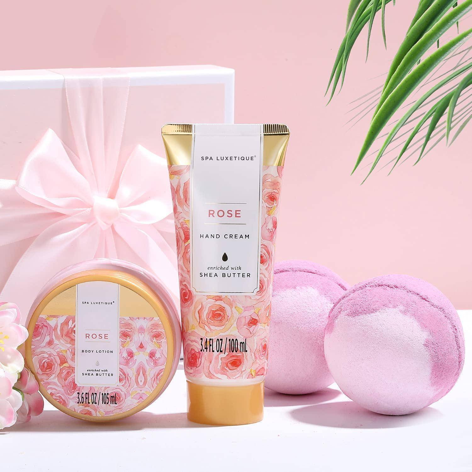 Spa-Set mit rosenthematischer Handcreme, Körperlotion und Badebomben in rosa Verpackung, präsentiert mit einer Geschenkbox und dekorativer Schleife.