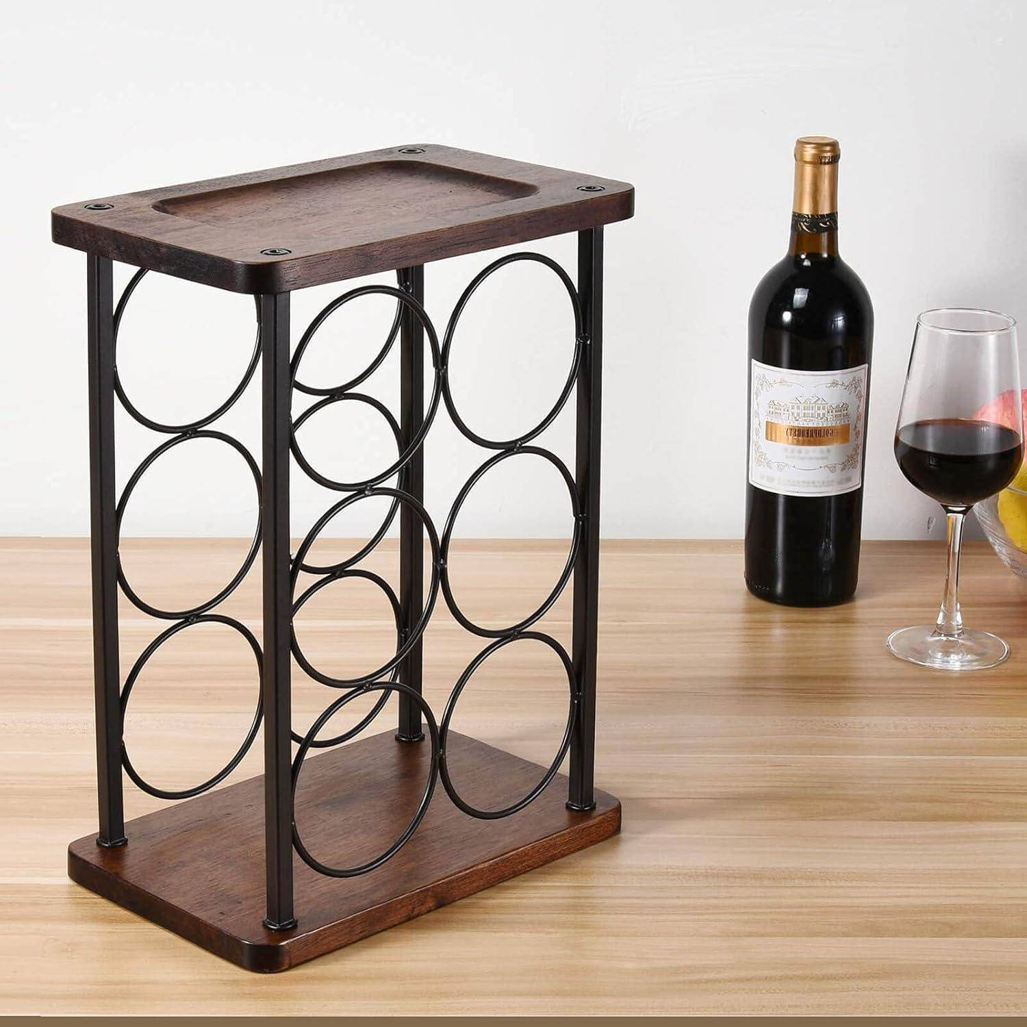 Ein Weinregal aus Holz mit Metallkreisen, das keine Flaschen enthält, steht auf einem Holztisch. Ein volles Glas und eine versiegelte Rotweinflasche befinden sich daneben.