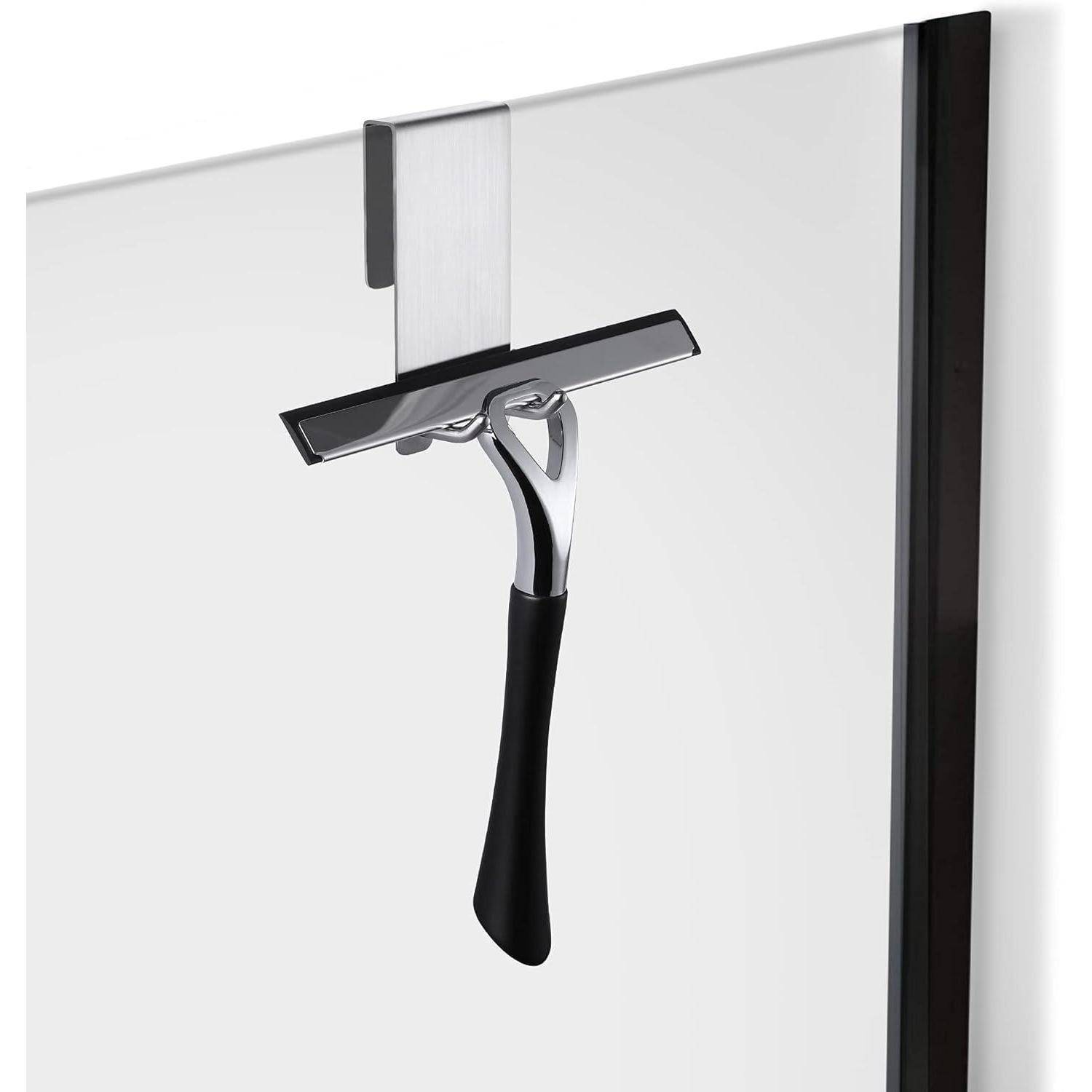 Ein schlanker Duschabzieher mit schwarzem Griff hängt an einem Metallhaken, der an einer Glasscheibe befestigt ist.