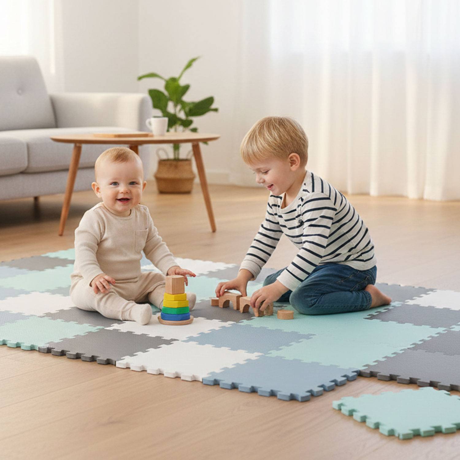 Zwei Kleinkinder spielen auf einer Schaumstoffmatte im Wohnzimmer. Eines stapelt Ringe, während das andere mit Holzklötzen spielt.