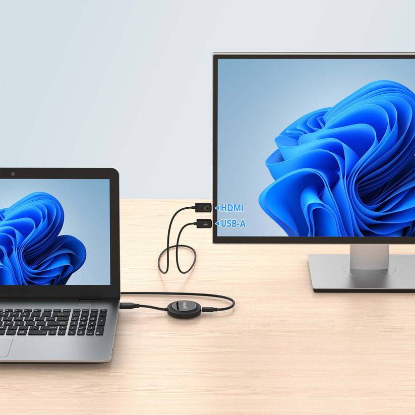 Laptop, der mit einem externen Monitor über HDMI- und USB-A-Kabel auf einem Schreibtisch verbunden ist, wobei beide Geräte denselben blauen abstrakten Bildschirm anzeigen.
