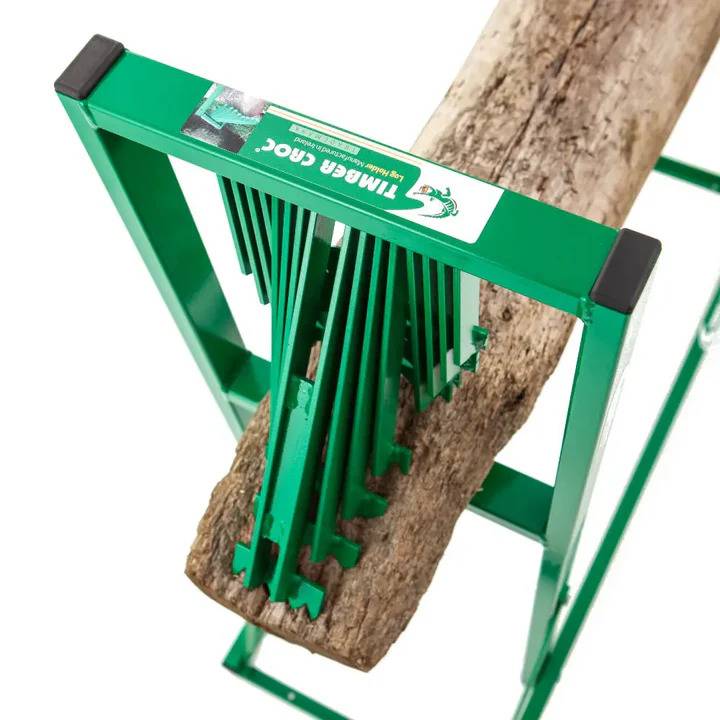 Ein Holzspalter mit einem grünen Metallrahmen hält einen Baumstamm fest und demonstriert seine Konstruktion zum Zerlegen von Holz in kleinere Stücke.