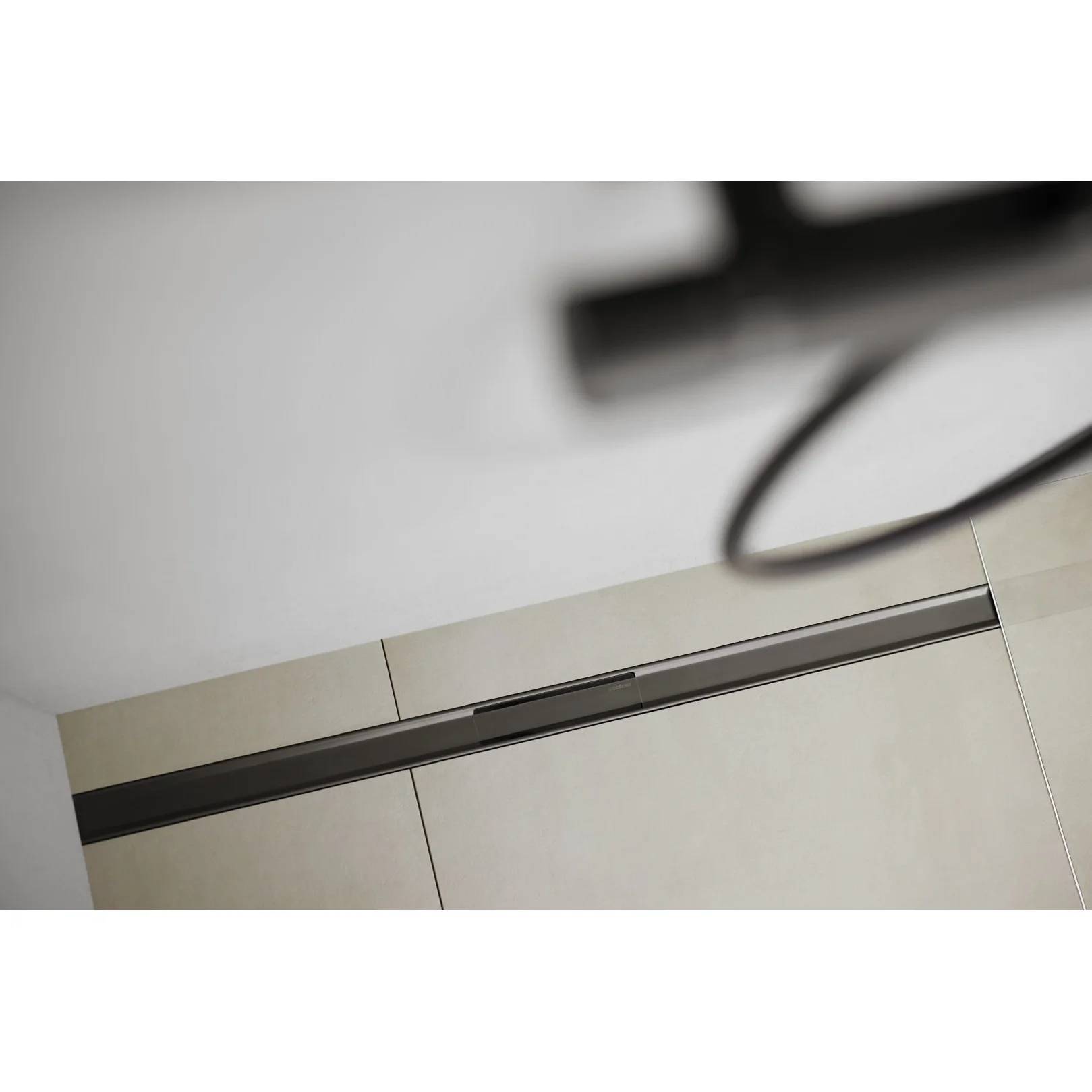 Geneigte Ansicht eines beigen Schranks oder Wandpaneels mit einer langen dunklen horizontalen Zierleiste; ein unscharfes Kabel oder eine unscharfe Griff ist oben in der Nähe sichtbar.