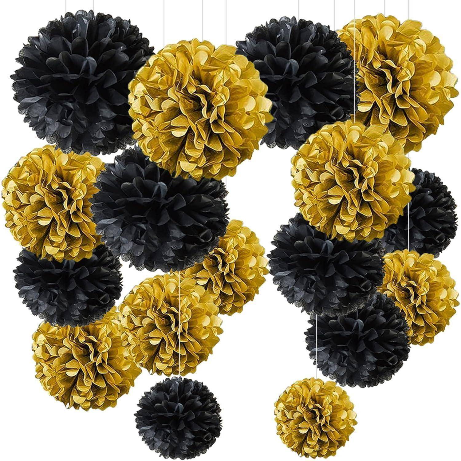 Ein Cluster aus dekorativen Papier-Pompons in unterschiedlichen Größen, in Schwarz und Gold, die an dünnen Schnüren vor einem weißen Hintergrund hängen.