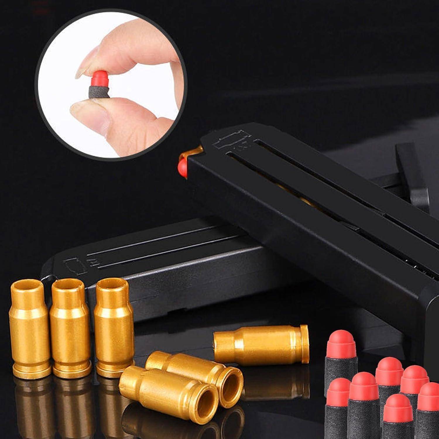 Eine Person hält eine kleine Gummigeschoss mit roter Spitze zwischen den Fingern. Mehrere Gummigeschosse sind unten ausgelegt, neben einem schwarzen Magazin.