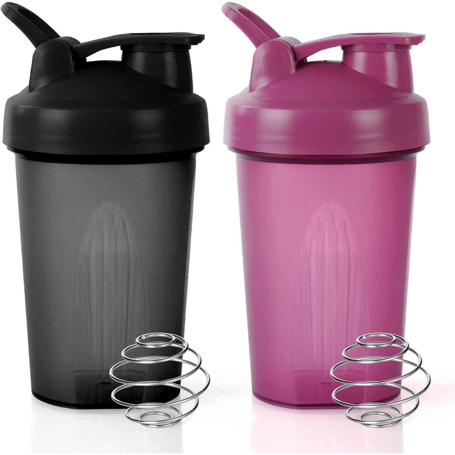 Zwei Plastik-Shakerflasche, eine schwarz und eine rosa, jeweils mit einem Drahtmischball davor.