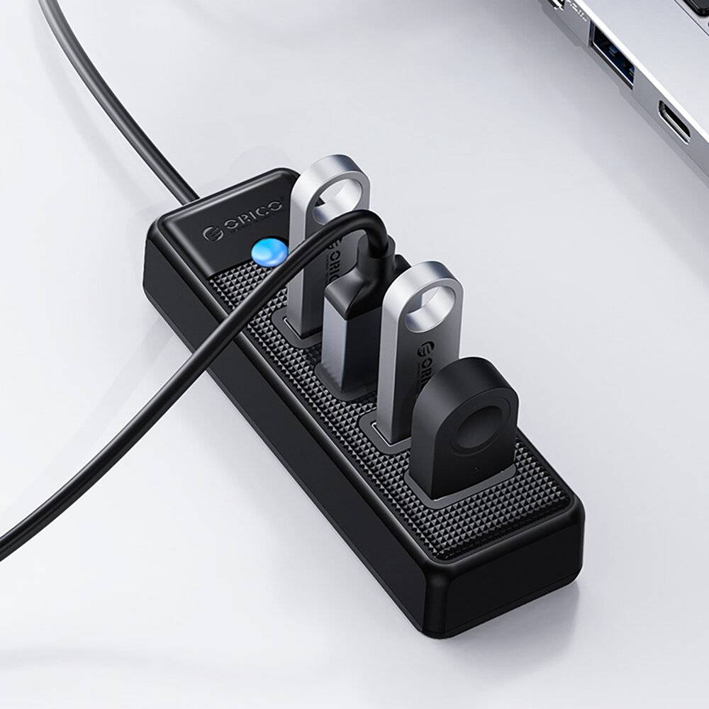Eine Steckdosenleiste mit drei USB-Laufwerken und einem angeschlossenen Stromkabel auf einer glatten grauen Oberfläche.