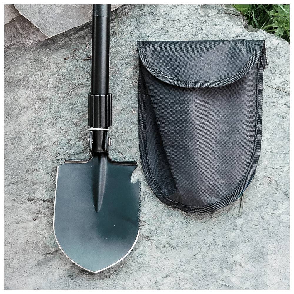 Eine kompakte, zusammengeklappte schwarze Schaufel mit gezackter Kante liegt neben ihrer schwarzen Transporttasche auf einer Steinoberfläche.